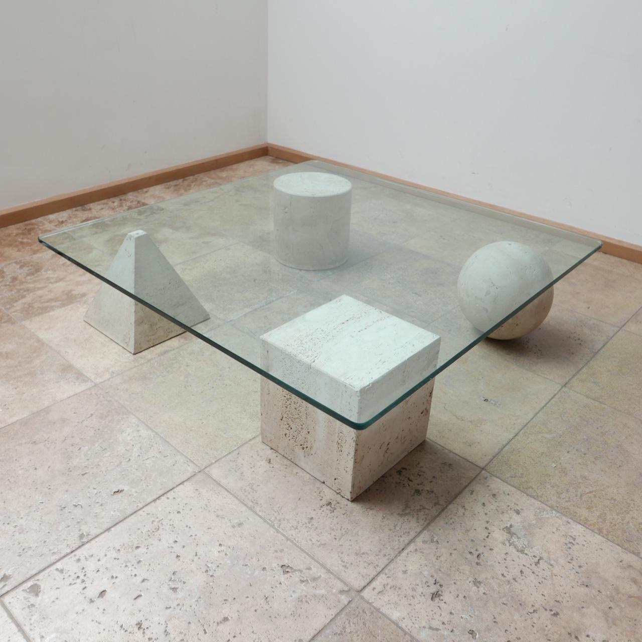 An Italian mid-century coffee table. 

Formed from solid travertine geometric shapes under a thick glass top. 

In the manner of the Metafora coffee table by Massimo and Lella Vignelli.

Likely produced by Cinna. 

Italy, c1980s. 

Glass is approx