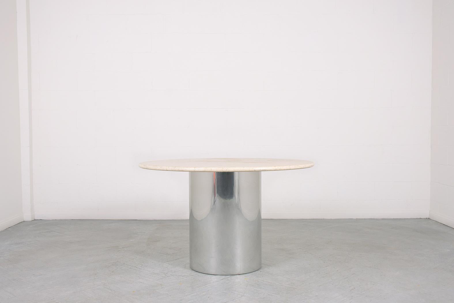 This extraordinary modern 1970s dining table is in great condition beautifully crafted out of steel & travertine marble and newly restored by our professional craftsmen team. This sleek mid-century dining room table features a circular Italian