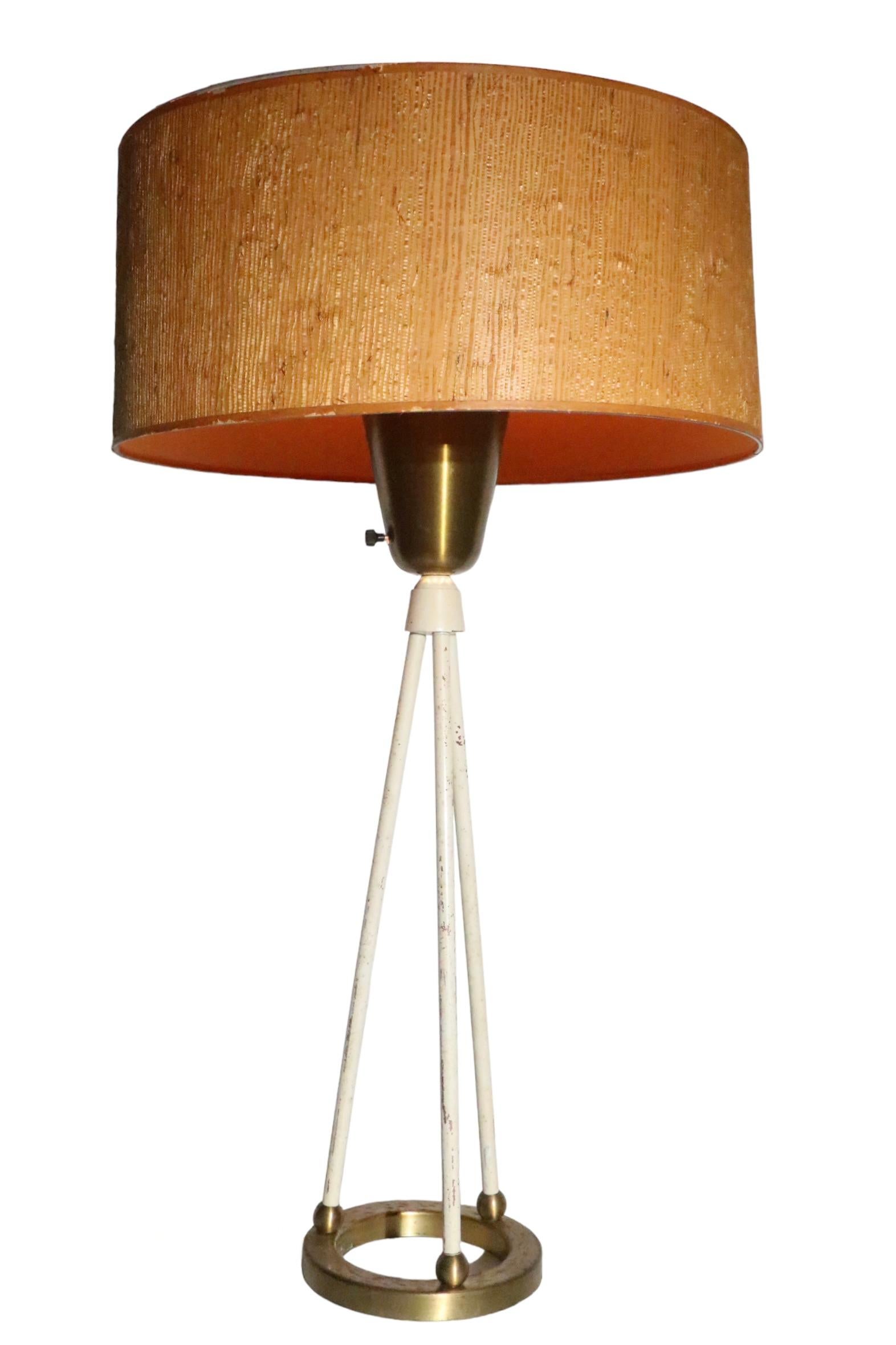Architectural design table lamp attributed to Gerald Thurston for Lightolier circa 1950's. The lamp features a ring firm base from which extend three rods that support a brass cup at the top. The lamp is in good, original, working condition, the
