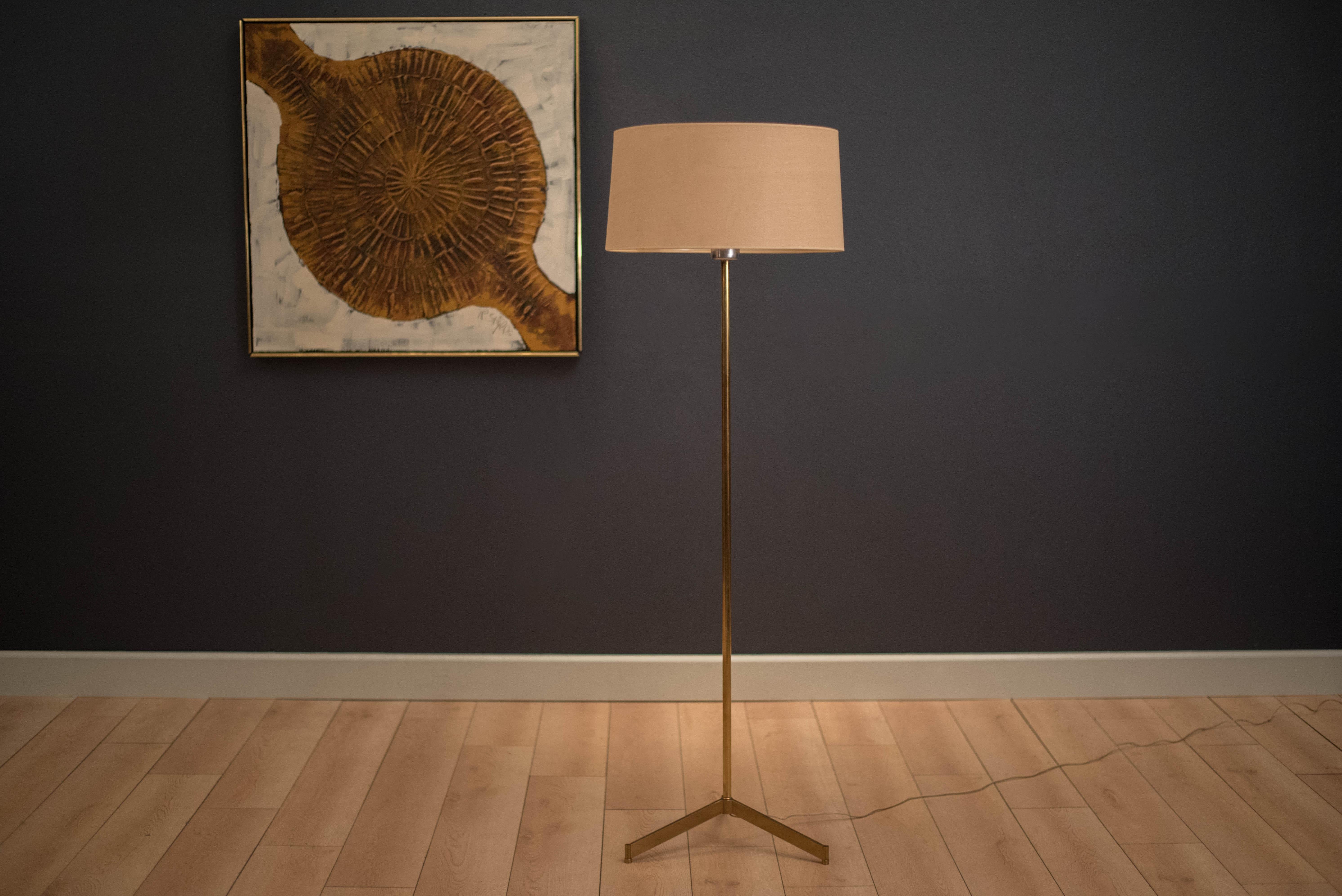 Mid century brass floor lamp in the manner of Paul McCobb. This tripod lamp includes a milk glass cone shade underneath the original drum shade.