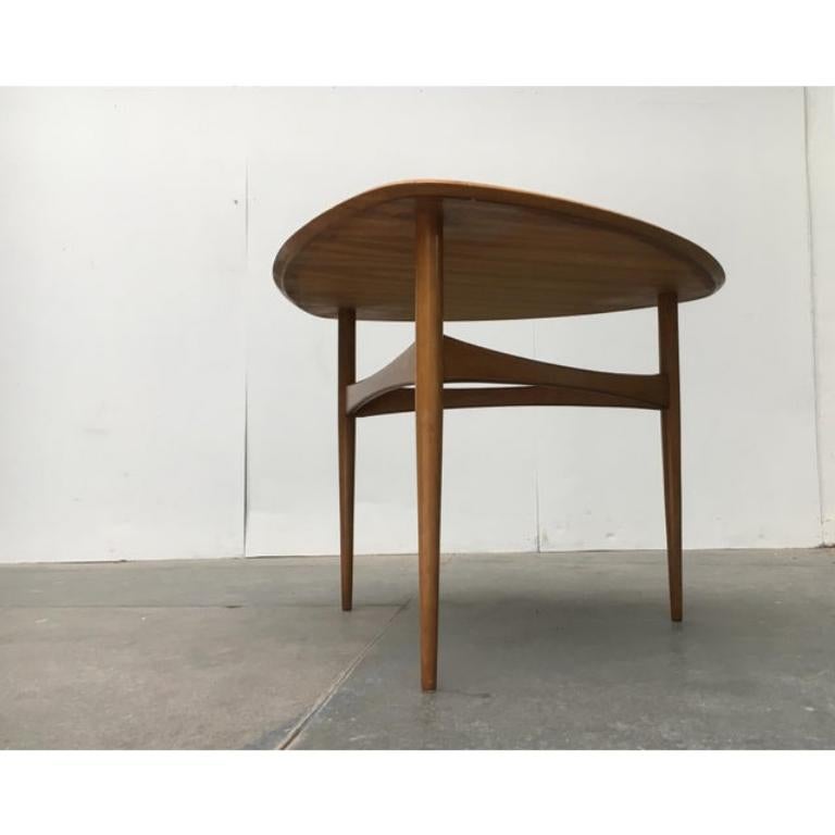 Table tripode du milieu du siècle.

Langage de conception très élégant, notamment dans la finition du plateau de table et l'interaction entre le plateau, les pieds en bois massif et les entretoises incurvées. La matérialité et la fabrication sont de