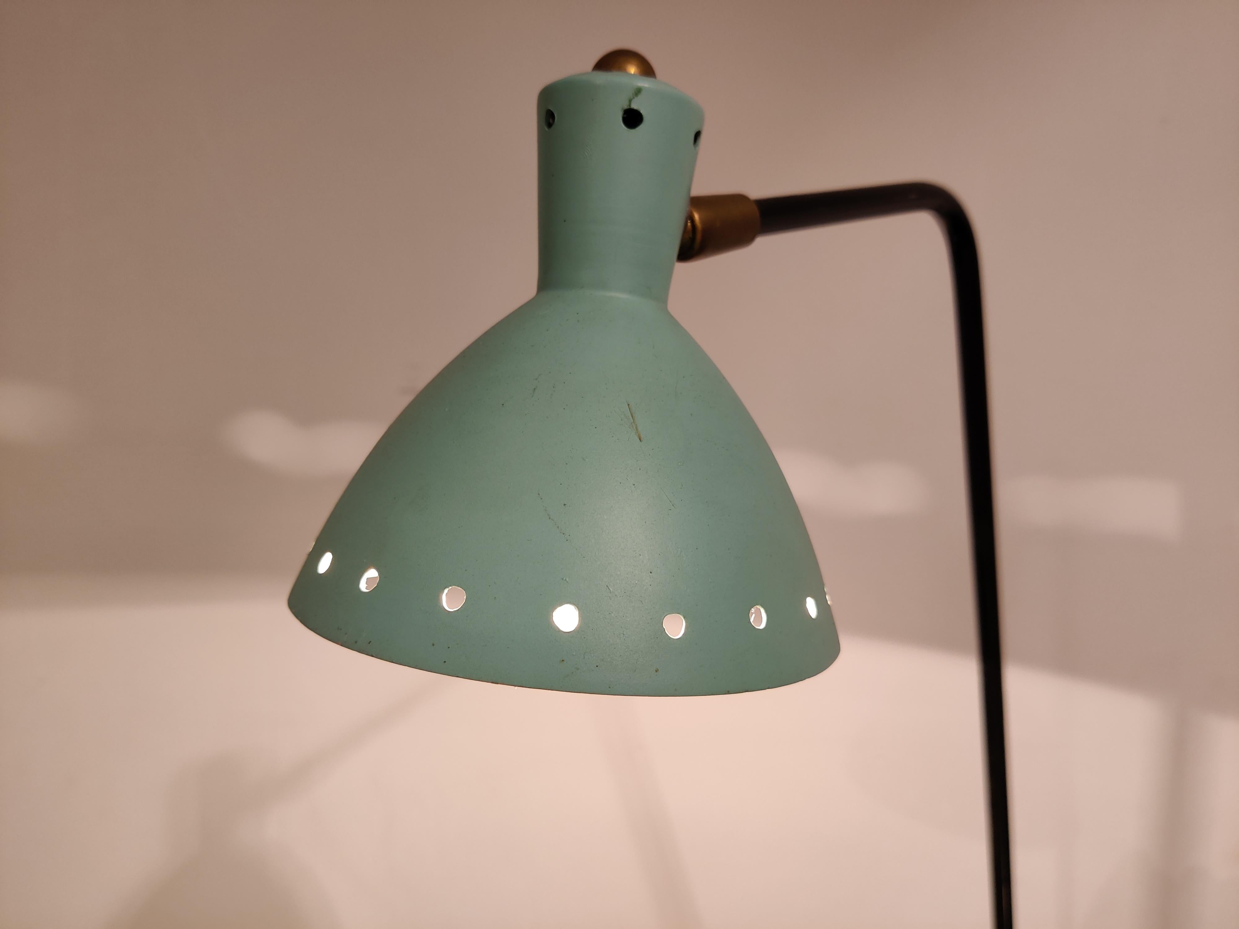Elegant mid century desk lamp with a metal and brass tripod base and a perforated aluminum green/blue lamp shade.

The lamp shade is articulated so you can position it in various ways. 

1950s - Italy

Works with a regular E14 light
