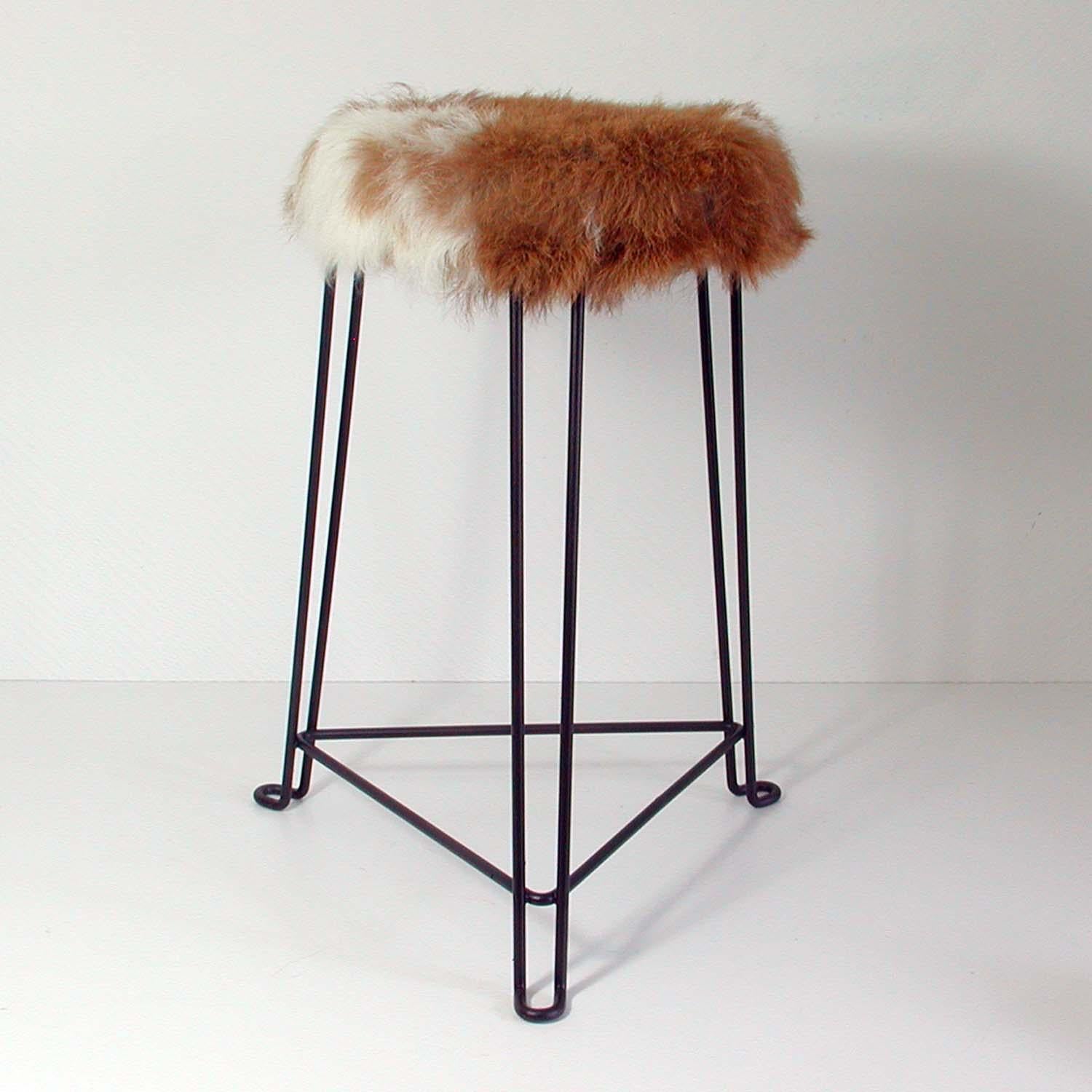 This industrial inspired stool was manufactured by Tomado in the Netherlands in the 1950s and designed by Jan Van Der Togt.

The stool is made of black lacquered tubular steel and has got a real goatskin seat in creme and toffee. The stool has