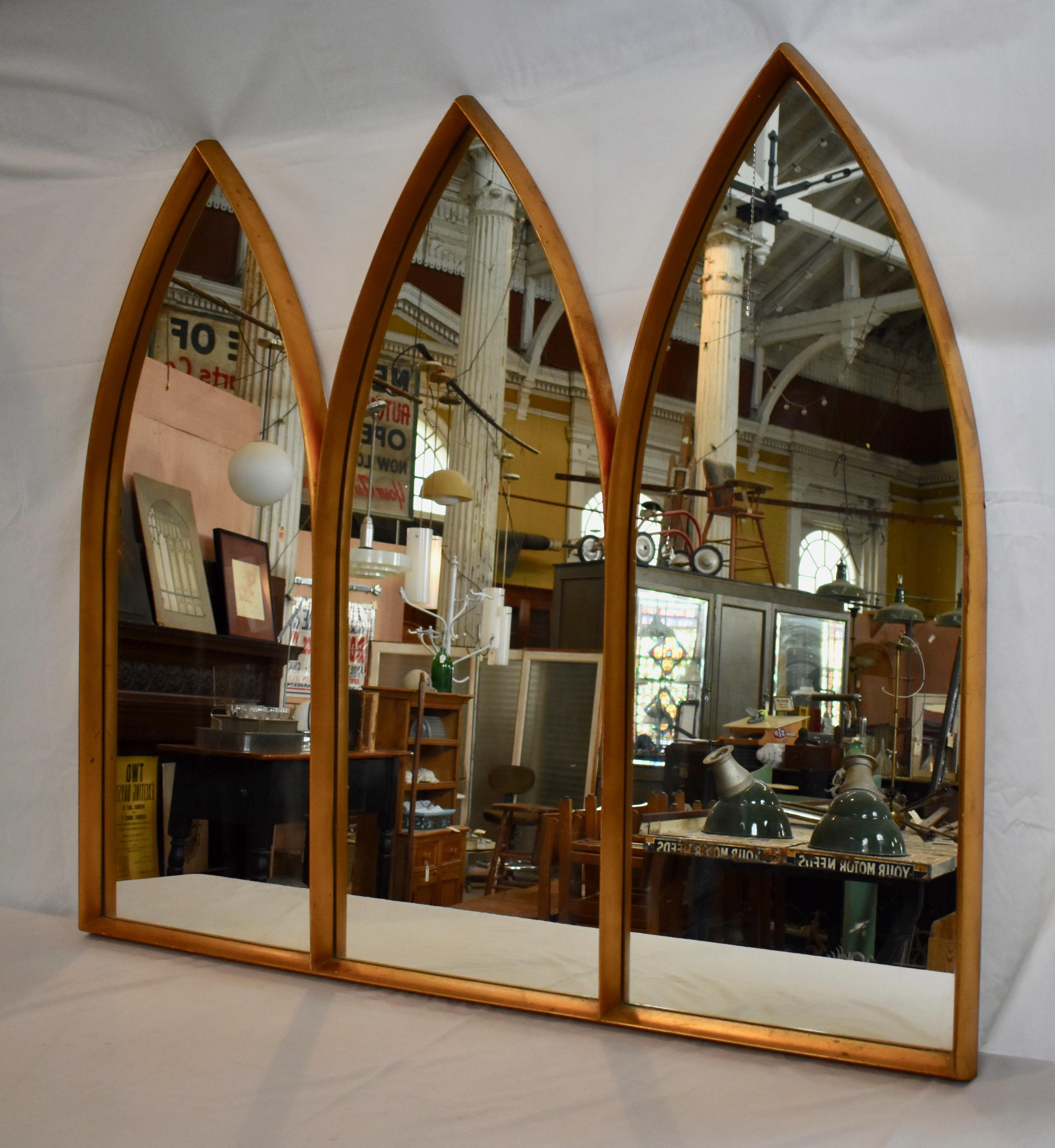 This is a triptych, lancet-arched Gothic mirror in gilt wood. Some minor gesso losses and scuffs, consistent with age and use.