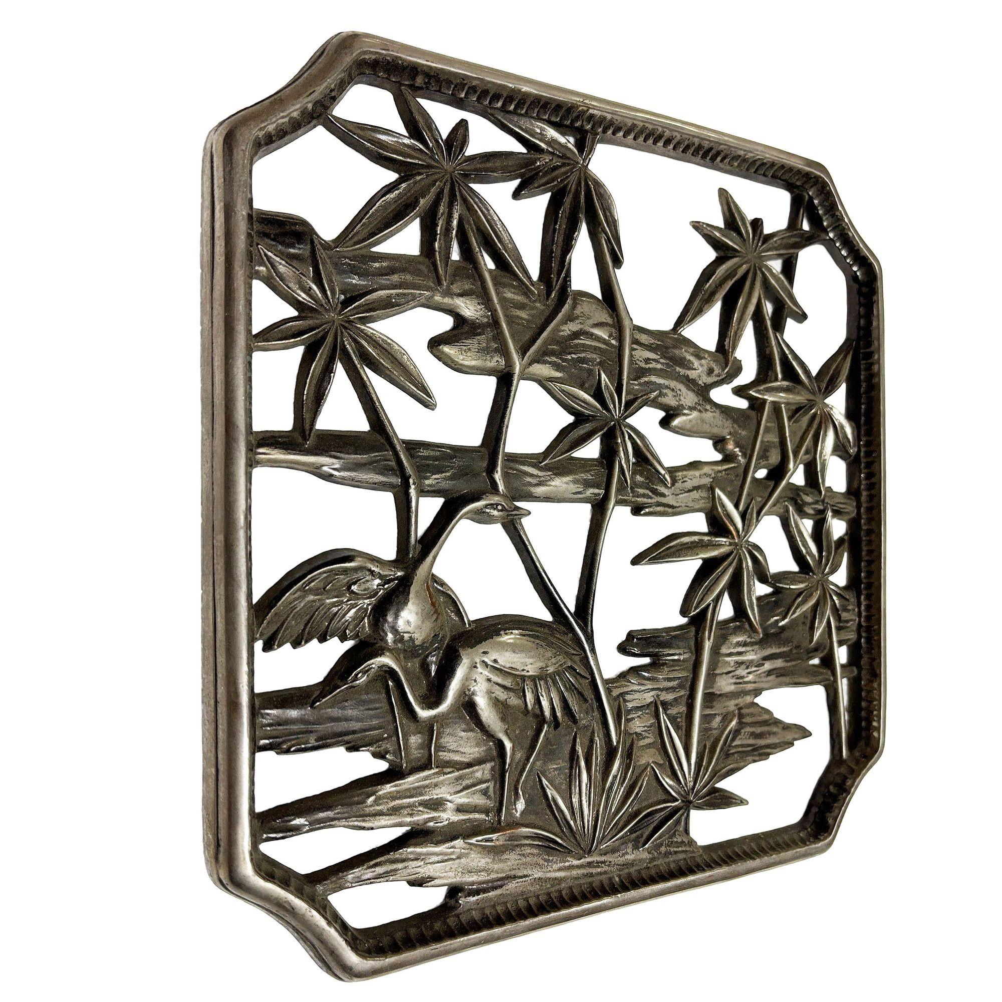 Wandskulptur aus handgegossenem Zinnmetall aus den 1950er Jahren mit einer tropischen Wasserszene mit Palmen und Kranichen von Syroco Wood Co. Das Bild ist in einen einzigartigen quadratischen 11-Zoll-Rahmen eingefasst.

Syroco Wood Co., kurz für
