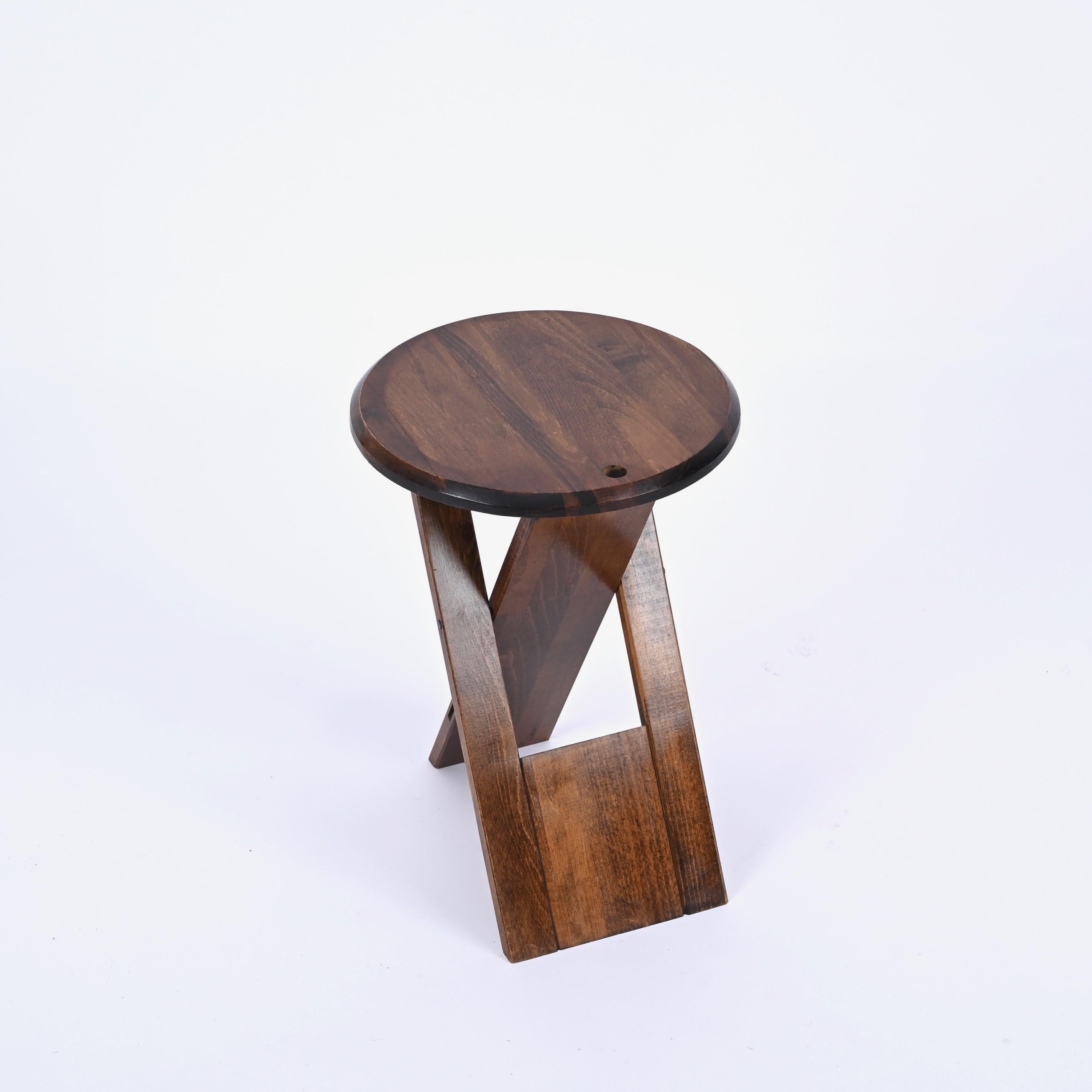 Stunning foldable TS stool in oak designed by Roger Tallon and produced by Sentou in France in the 1970s. 

This TS stool is fully made in a beautiful dark oak wood and was ingeniously designed to fold completely flat with the possibility to be hung