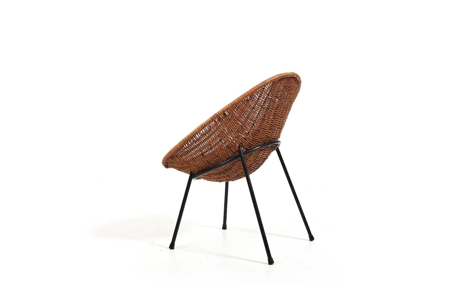 Vintage rattan chair with black laquered metal base. Produced 1950s.