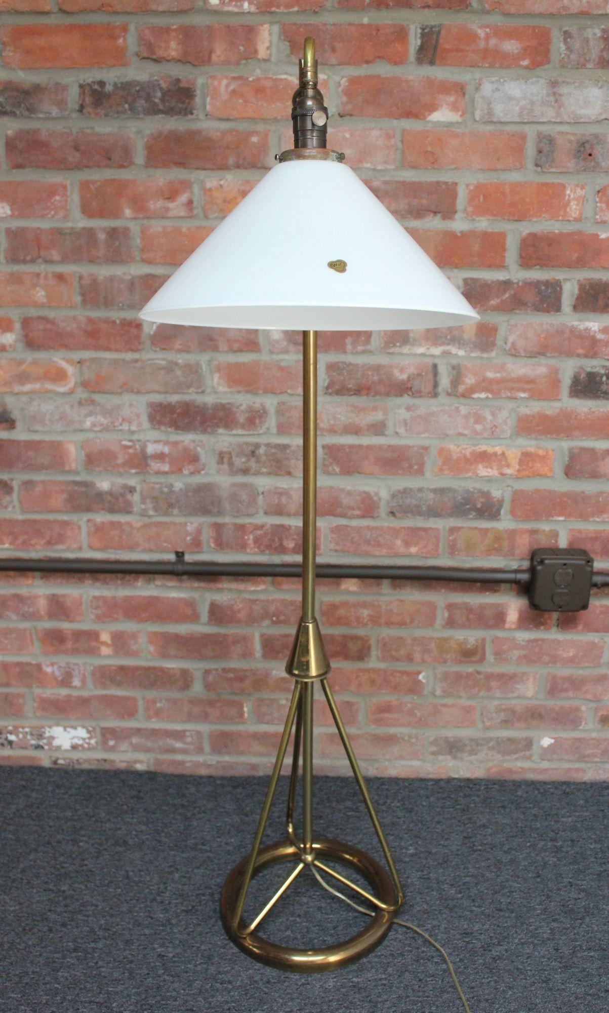 American Modern floor lamp with brass rod construction supported by a round tubular brass base (ca. 1950s).
Features a brass arm with chrome orb finial (decorative purposes only; arm does not adjust).
The French milk glass shade by CVV Vianne was a