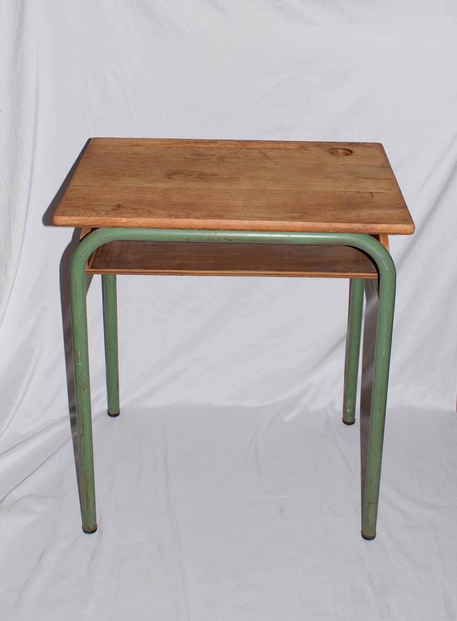 This vintage desk dates from the 1950s/1960s. It is designed in the style for Jacques Hitier. The metal frame is painted in a great verde green colour whilst the tabletop still retains its original wood with an inkwell located in the top right hand