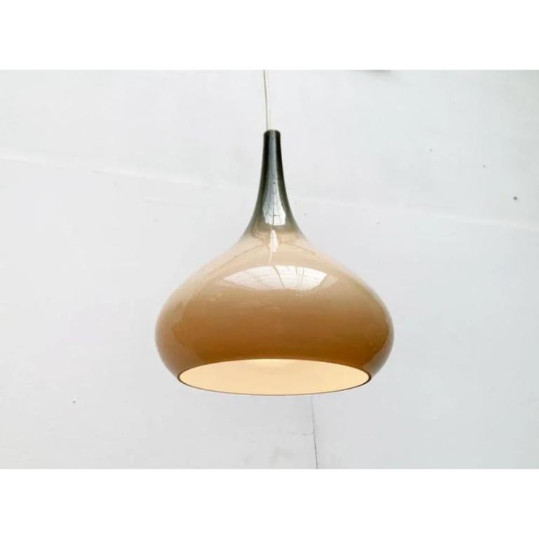 Lampada a sospensione in vetro del produttore danese Nordisk Solar e Holmegaard in un colore speciale.

Il corpo dell'apparecchio, a forma di goccia, è realizzato interamente in vetro opalino e grigio su grigio. La particolarità è la sottile