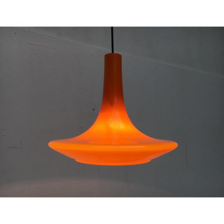 Dondolo in vetro arancione della metà del secolo scorso del rinomato produttore Peill & Putzler, Germania.

Il design degli anni '70 mostra la tipica forma a tulipano. Si adatta al colore arancione. Il corpo del Luminaire è in vetro soffiato. Oltre