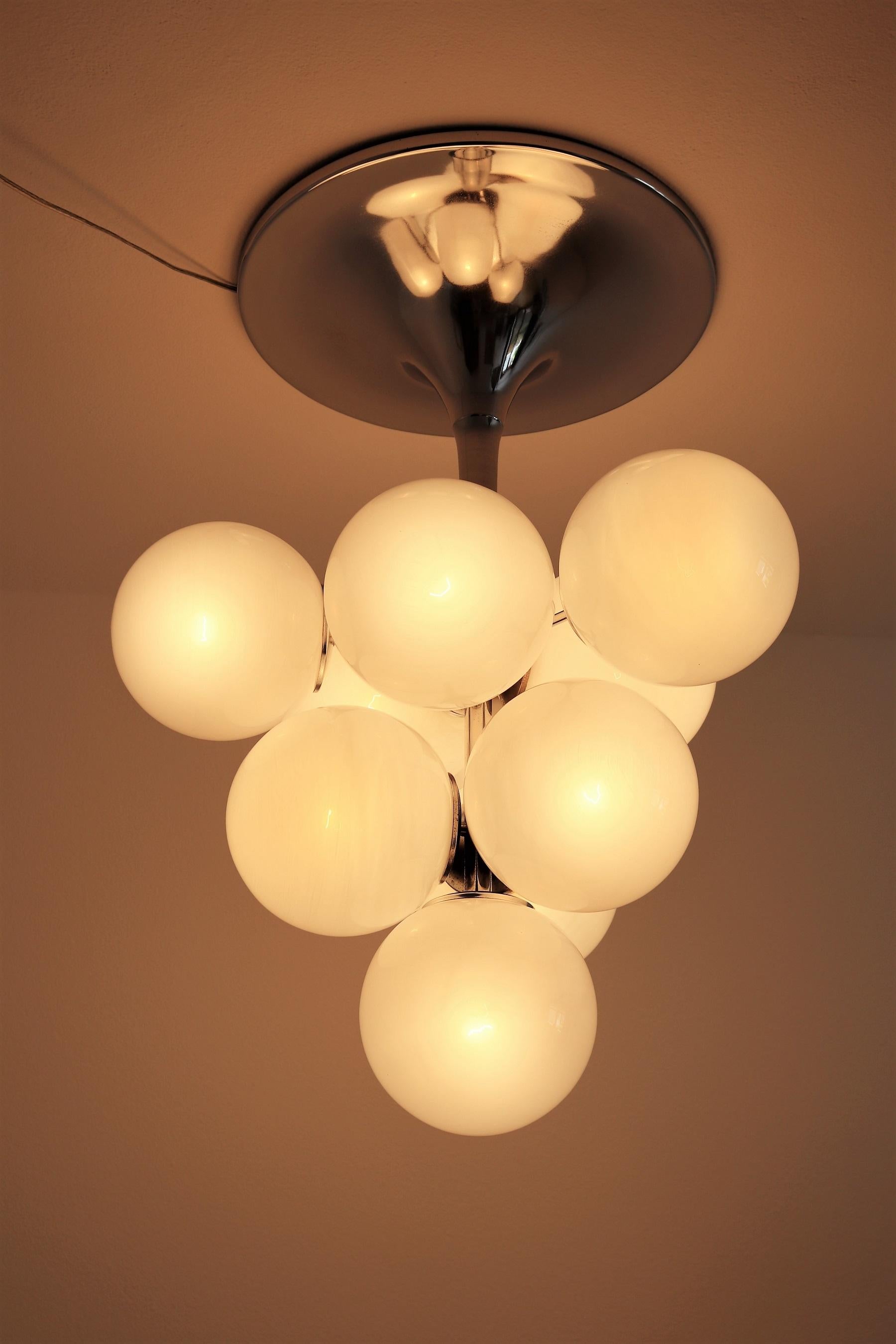 Beautiful and particular chandelier made of 10 strong white glass spheres on chromed lamp's base in tulipan shape.
Designed by E. R. Nele, Germany and produced by Temde Switzerland in the 1960s.
All glasses and the lamp's base are in very good