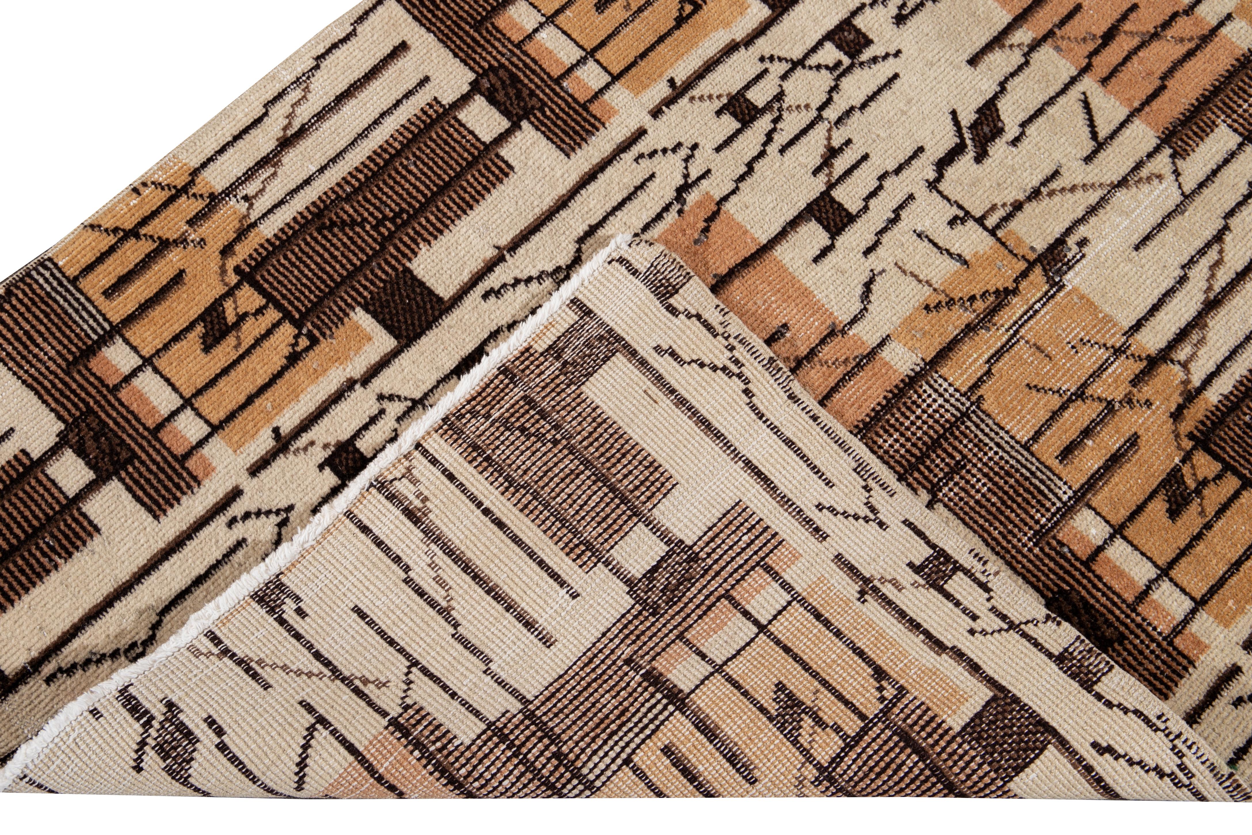 Beautiful vintage Turkish hand-knotted wool runner with a beige field. This Turkish runner has a brown and tan accent in a gorgeous all-over Abstract Expressionist design.

This runner measures: 2'10