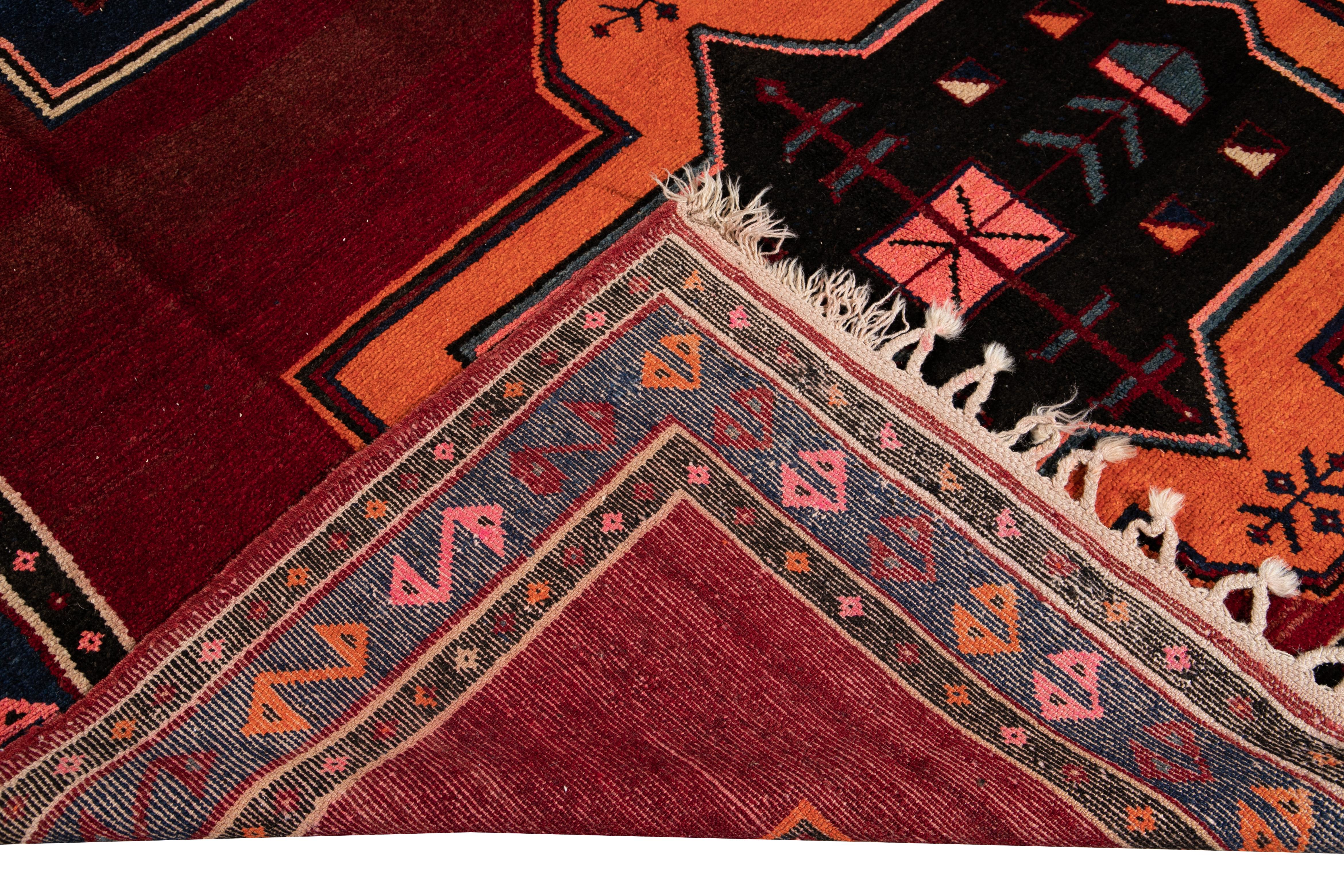 Bellissimo tappeto vintage turco in lana annodato a mano con campo rosso. Questo tappeto turco ha una cornice blu e marrone e accenti multicolore in uno splendido disegno tribale geometrico all-over.

Questo tappeto misura: 7'7