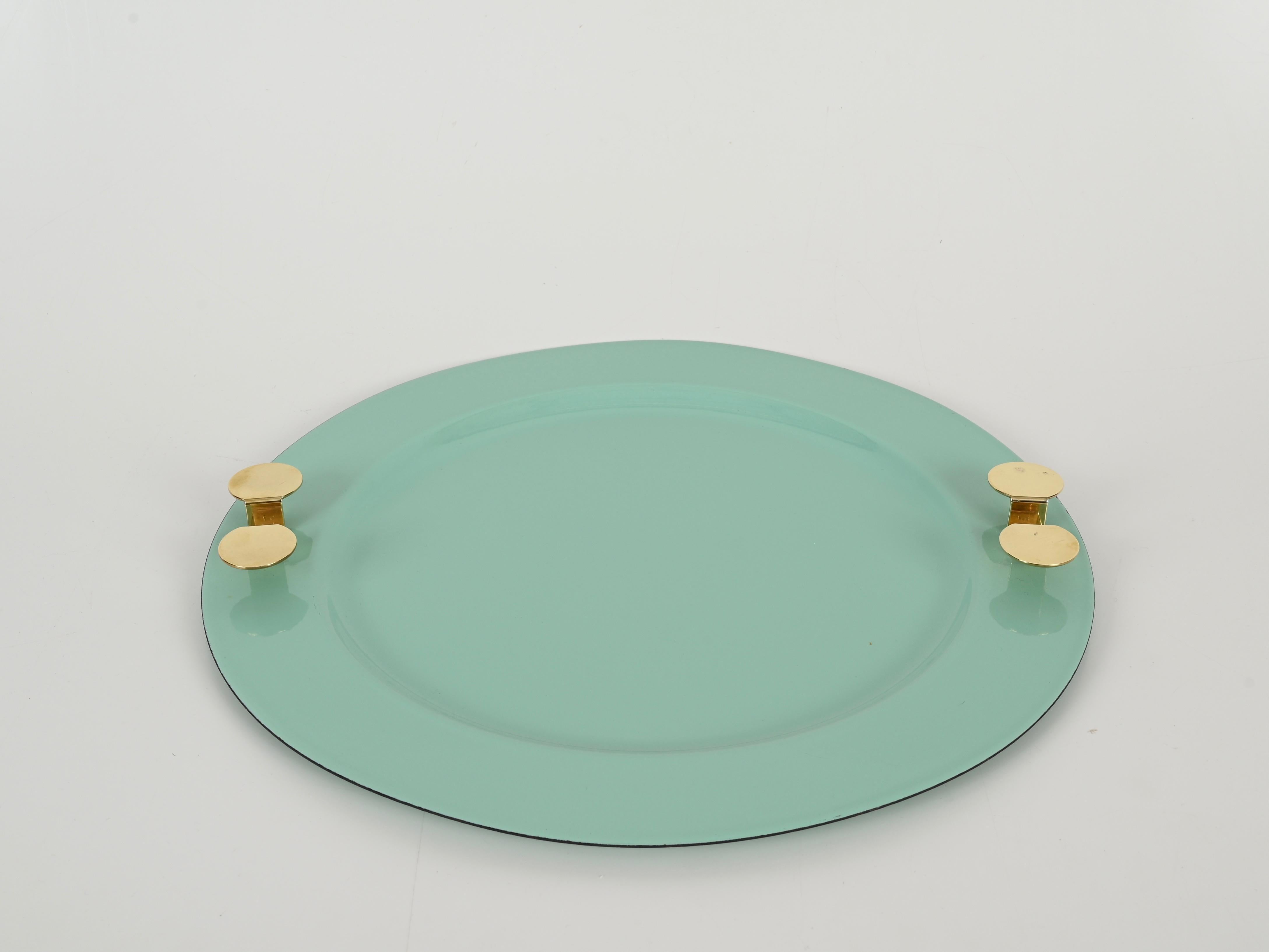 Wonderful mid-century round tray in turquoise enameled metal with brass handles.  This marvelous object was designed by Ambrogio Pozzi and produced by Padova Argenti in Italy during the 1970s. The tray is signed on the bottom.

In amazing condition.