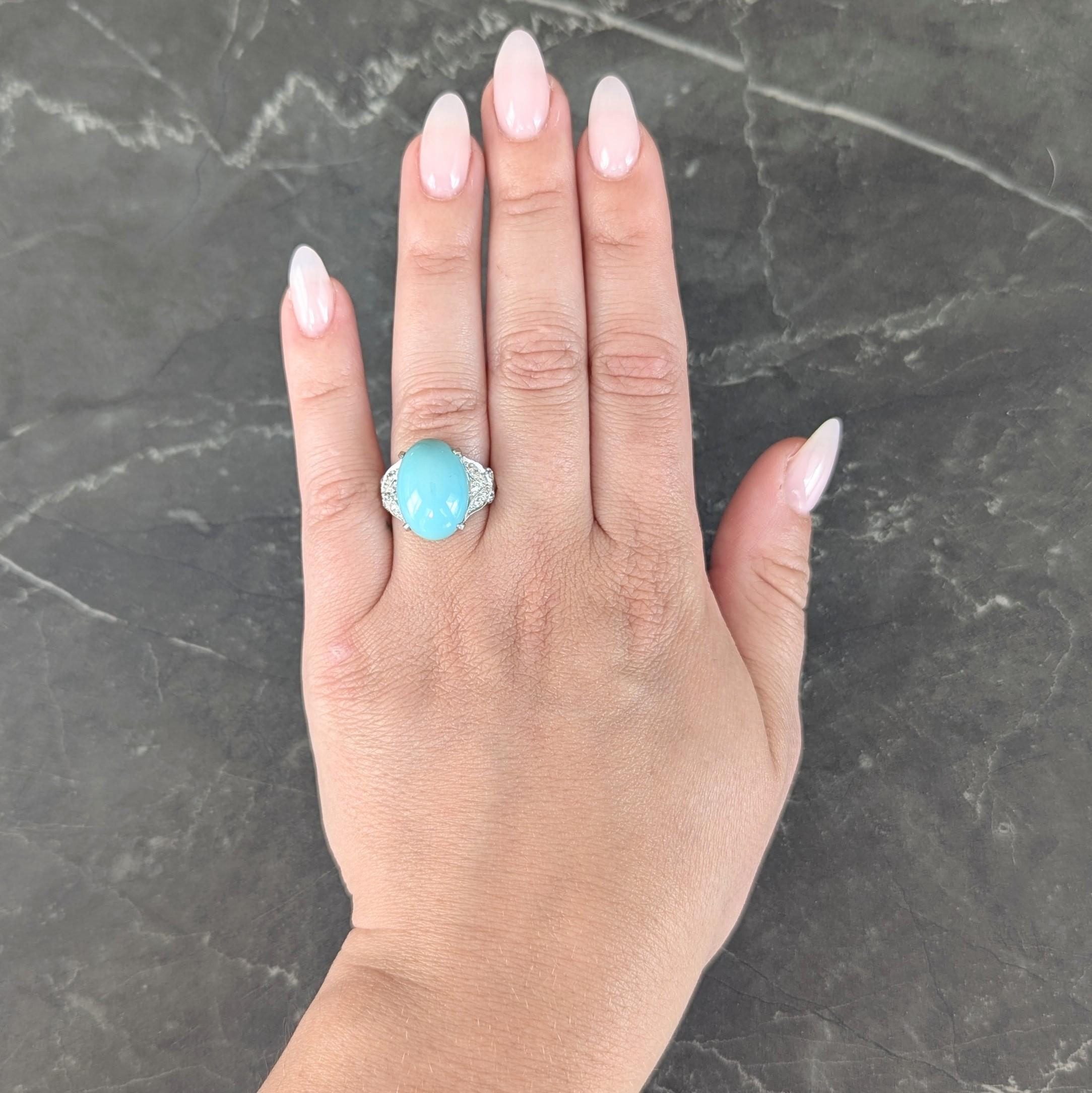 Centering an oval shaped cabochon measuring 17.0 x 12.0 mm - opaque robin's egg blue in color
Prong set and flanked by butterfly motif shoulders bead set with diamonds
Old European cut and weighing approximately 0.42 carat total
H color with VS2