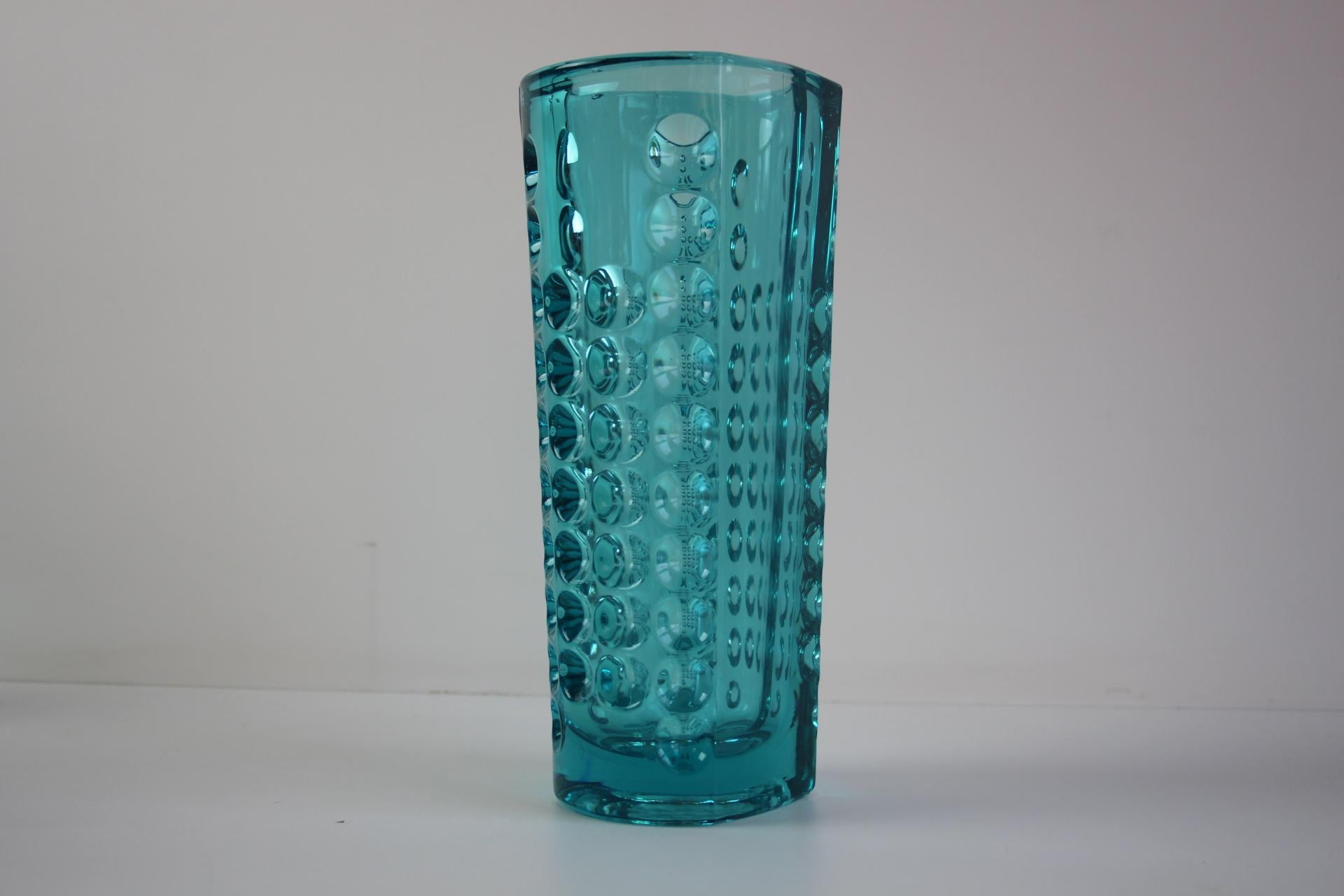 A refined and highly collectible mid-century modern pressed glass vase designed by Rudolf Jurnikl for Rudolfova Huť in 1960. This tall cylindrical vase showcases a vibrant turquoise blue hue and a beautifully executed geometric pattern of indented