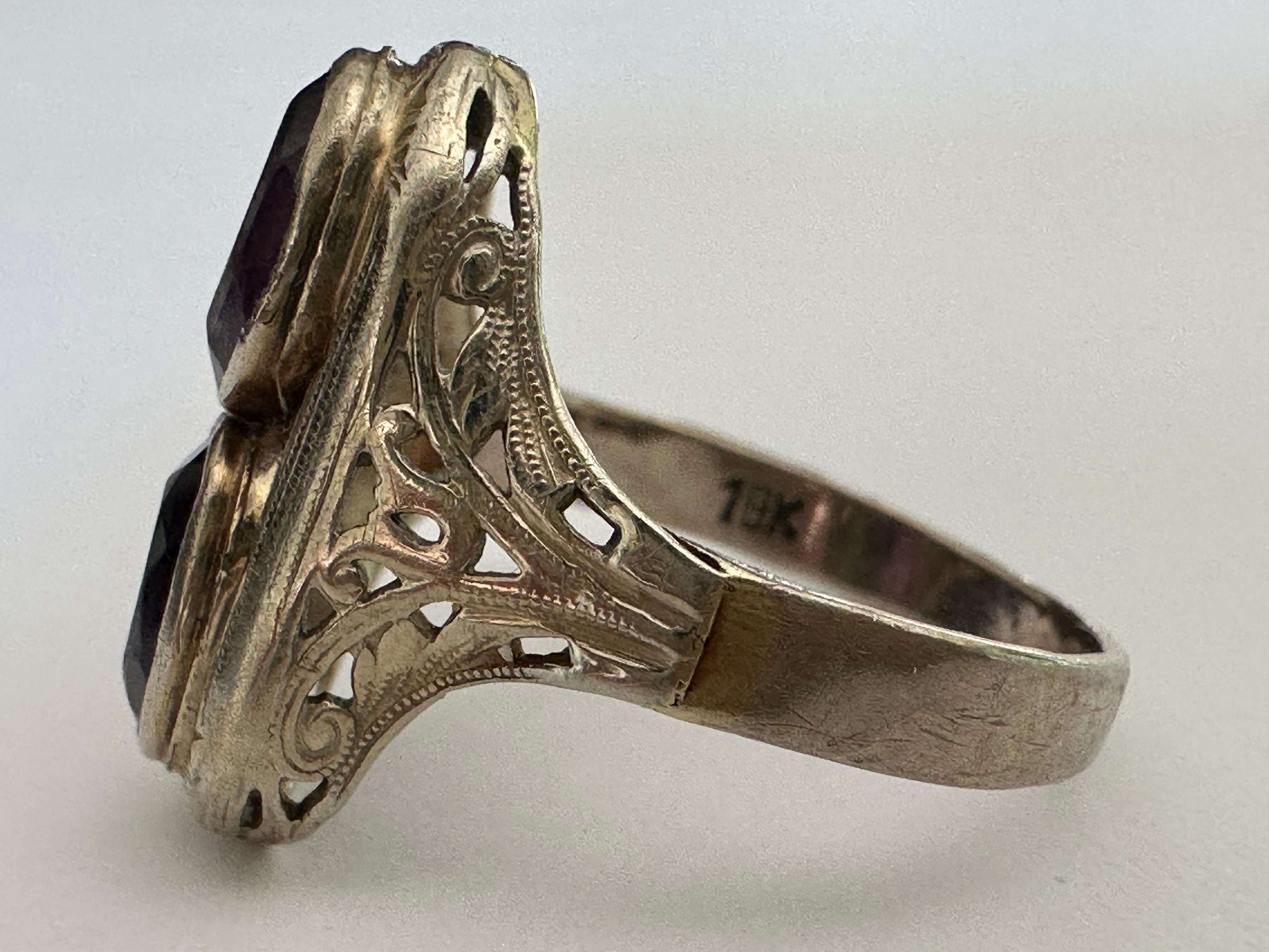 Dieser Vintage-Ring aus den 1940er Jahren ist aus 18 Karat Weißgold in Nord-Süd-Ausrichtung gefertigt und mit zwei ovalen Amethysten und feiner Filigranarbeit verziert. 

