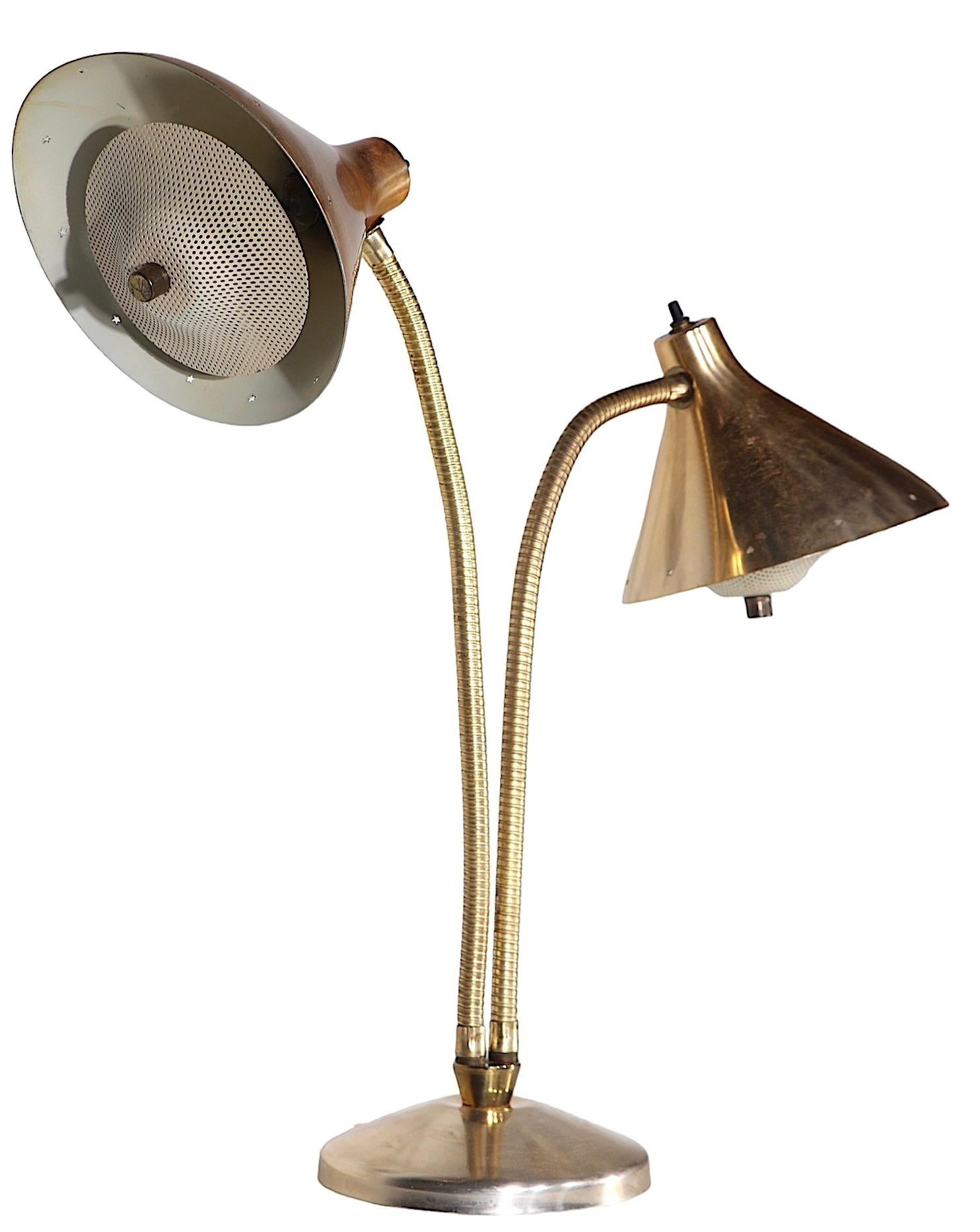 Chic deux lumières  Lampe de bureau à bras flexible, construite en aluminium anodisé de tonalité or/laiton, laiton et acier. La lampe comporte deux abat-jour à capuchon, chacun ayant encore son diffuseur perforé à clip d'origine. Probablement conçu