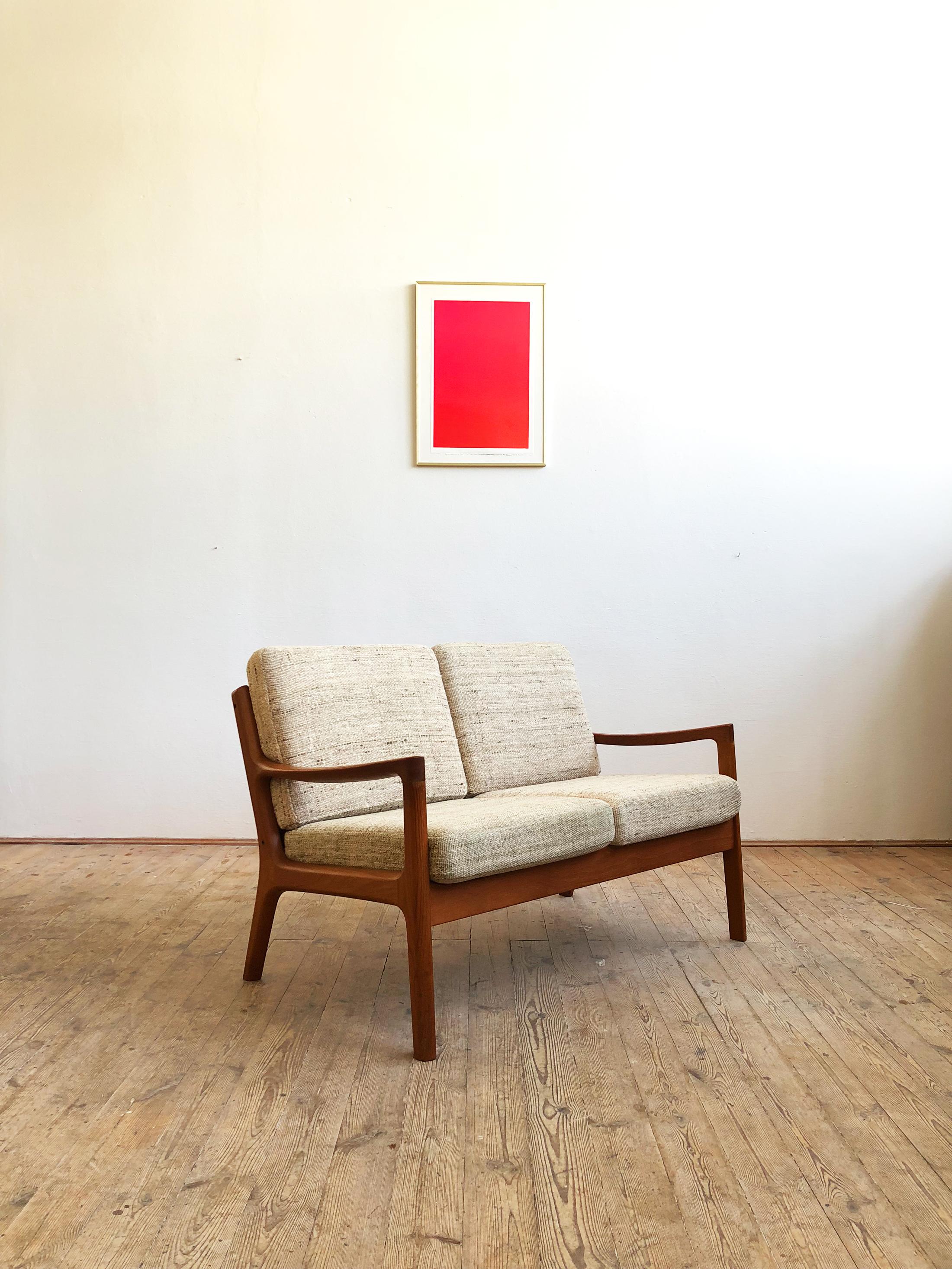 This shapely and comfortable sofa was designed by Ole Wanscher for France and Son. This piece comes in a two-seat version made of solid teak wood with box spring cushions and woolen cover.