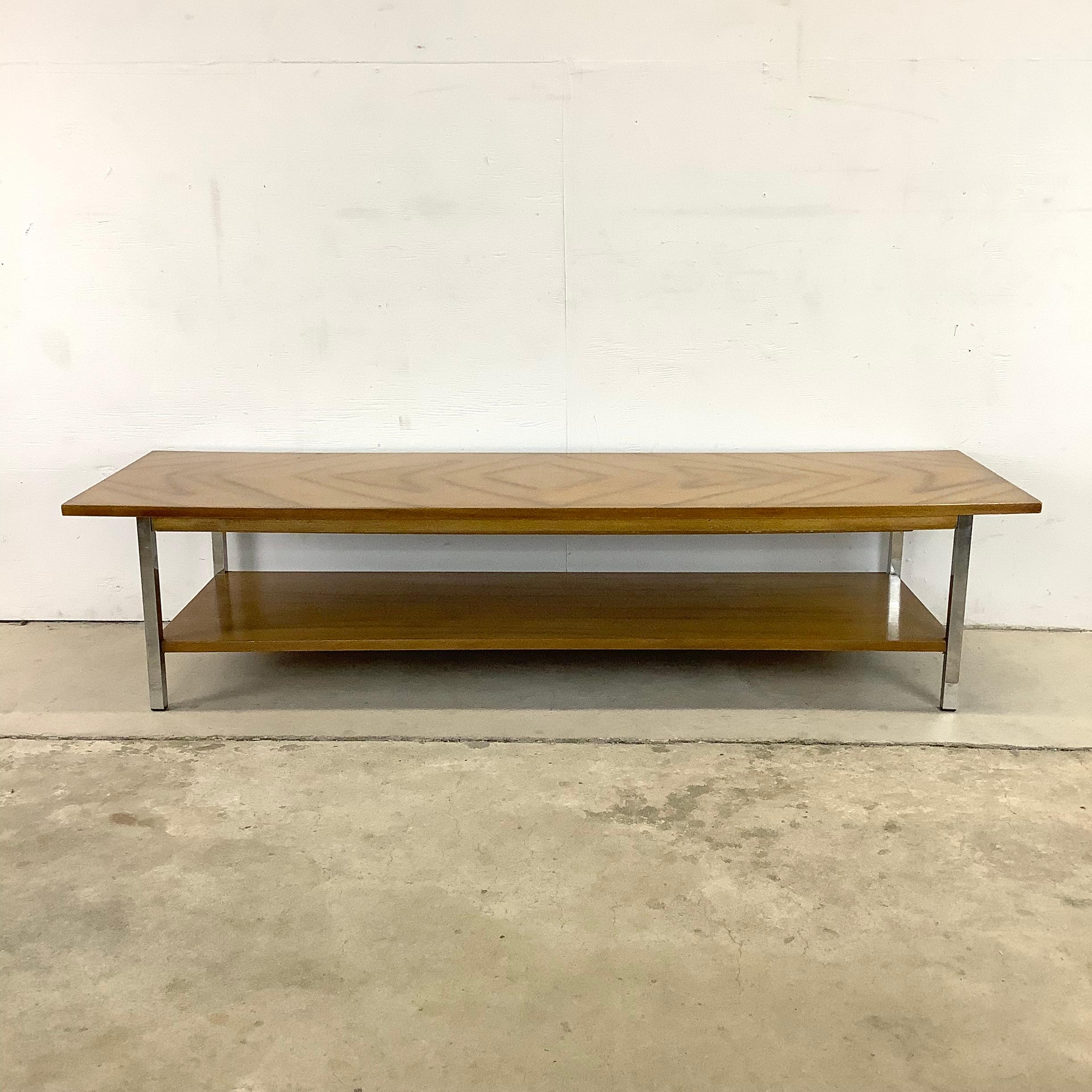 This stylish midcentury coffee table features a striking matched wood finish with sturdy chrome frame. The two tier design features substantial vintage construction and makes a striking mcm addition to any interior setting-

Dimensions: 54w 17.75d