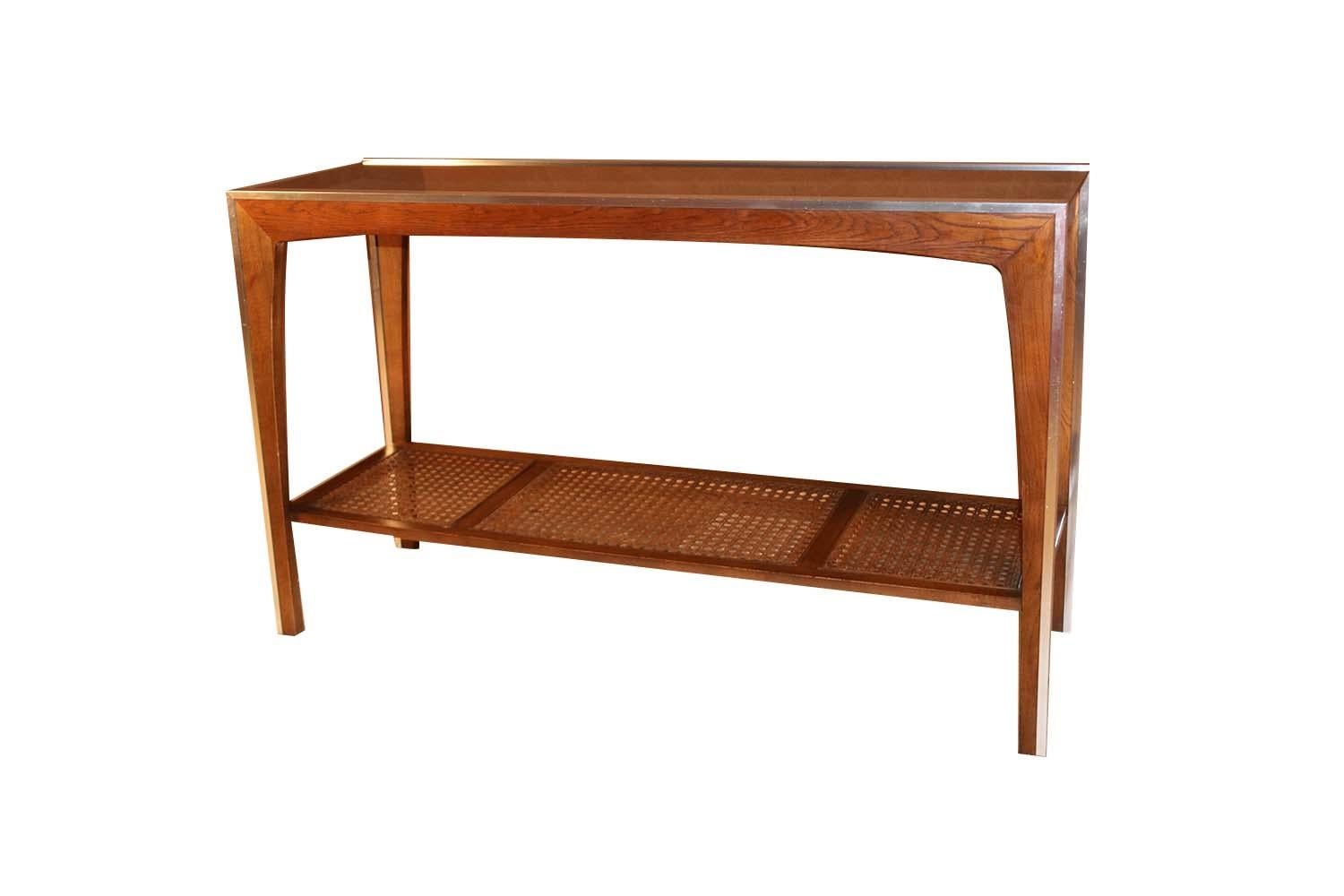 A walnut Mid-Century Modern two-tier console table in the style of Severin Hansen. Features a mirrored chrome framework with gorgeous warm walnut grain detail, fitted with a dark, smoked glass top, very Minimalist, modern aesthetic, a sleek