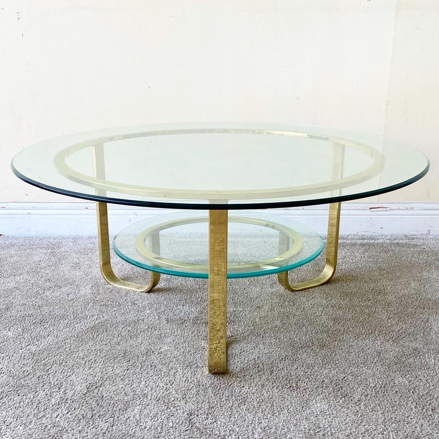 Amazing mid century modern two tier circular coffee table. Features a gold frame a two circular glass tops.
