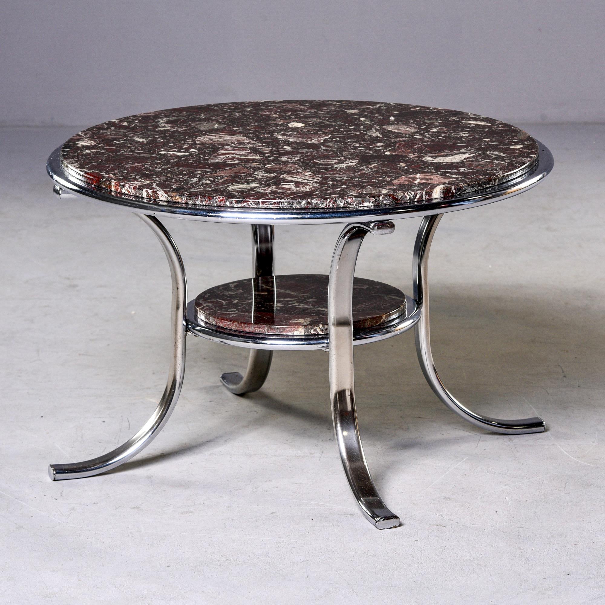 Found in England, this circa 1970s cocktail table has a polished nickel frame and two round tiers of deep wine, cream and black colored marble inserts. Unknown maker. 

Measures: Bottom shelf 13.75” x 9.5”.