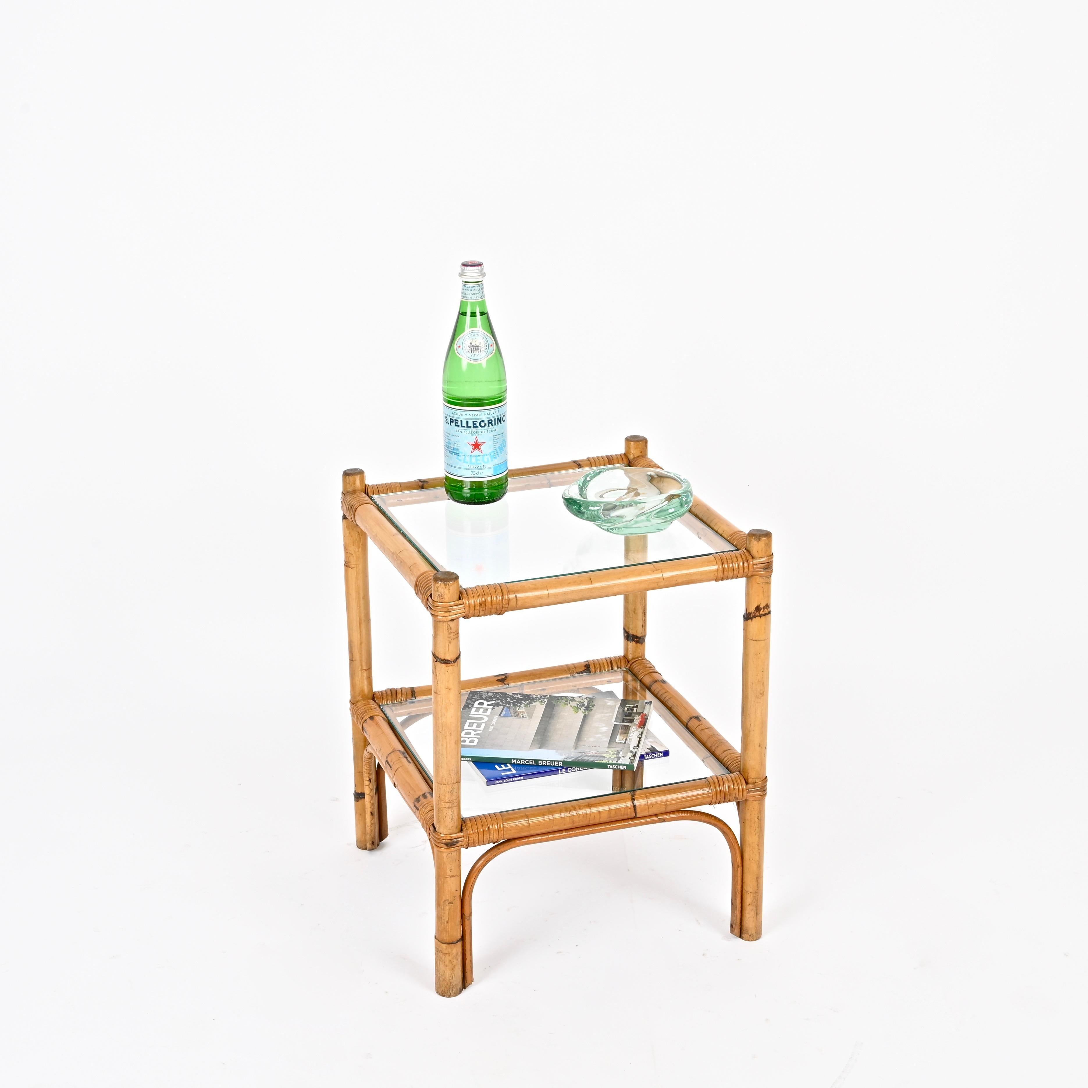 Stunning Mid-Century square side table fully made in bamboo and hand-woven wicker, completed with two crystal glass tops. This delightful organic piece was produced in Italy during the 1960s.

In amazing condition and featuring a charming honey