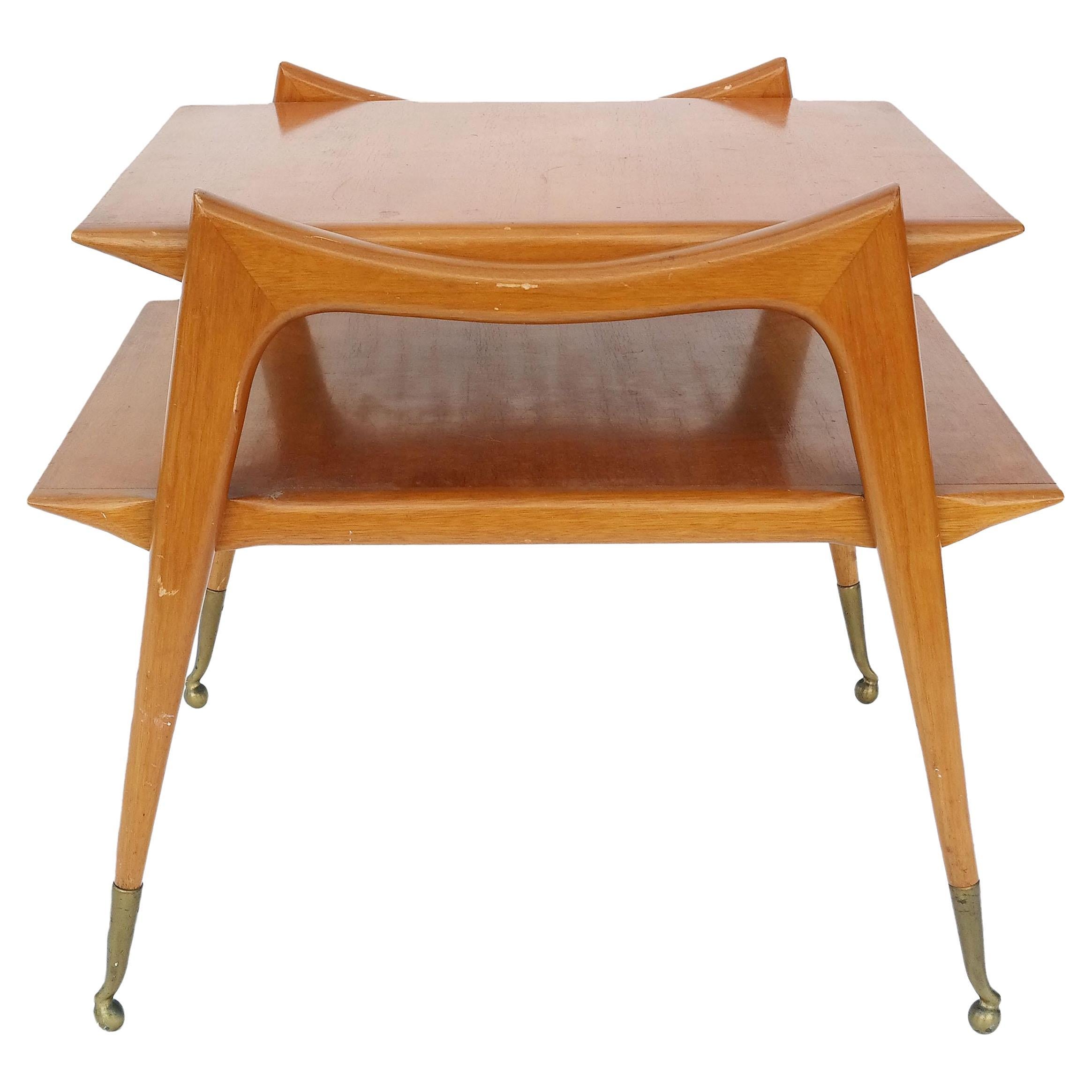Eleganter italienischer zweistöckiger Beistelltisch der Moderne, um 1950

Fein konstruiert aus Walnuss-Hartholz mit zwei Etagen, die von länglichen  Die konisch zulaufenden Beine enden in massiven Messing-Sabots, und die nach oben gebogenen