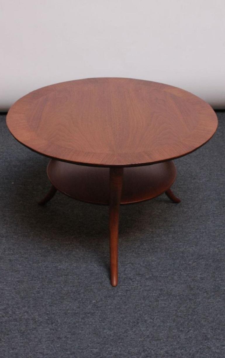 Mid-Century walnut occasional / coffee / cocktail table designed by T.H. Robsjohn-Gibbings for Widdicomb. Composed of two round surfaces supported by three, dramatically splayed, klismos-style / sabre legs.
Conservatively refinished; only light