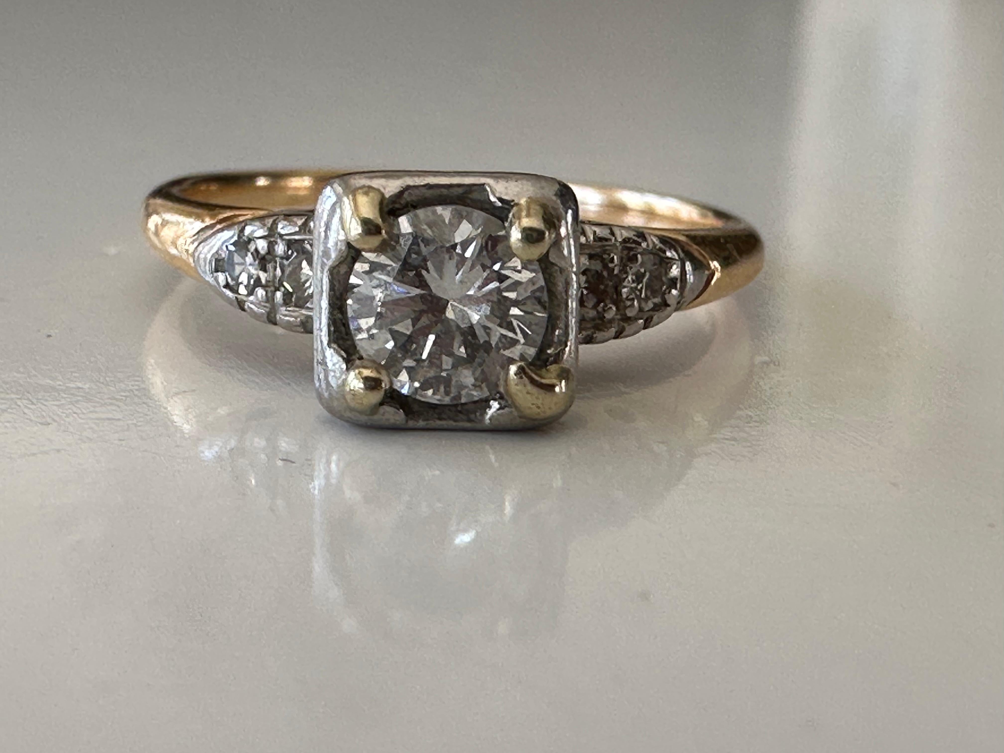 Crafted in the 1940s in 14k yellow and white gold, this stunning two-tone ring is designed around an Old European cut center stone measuring approximately 0.40 carats, F color, VS clarity and accented with four single cut diamonds. 