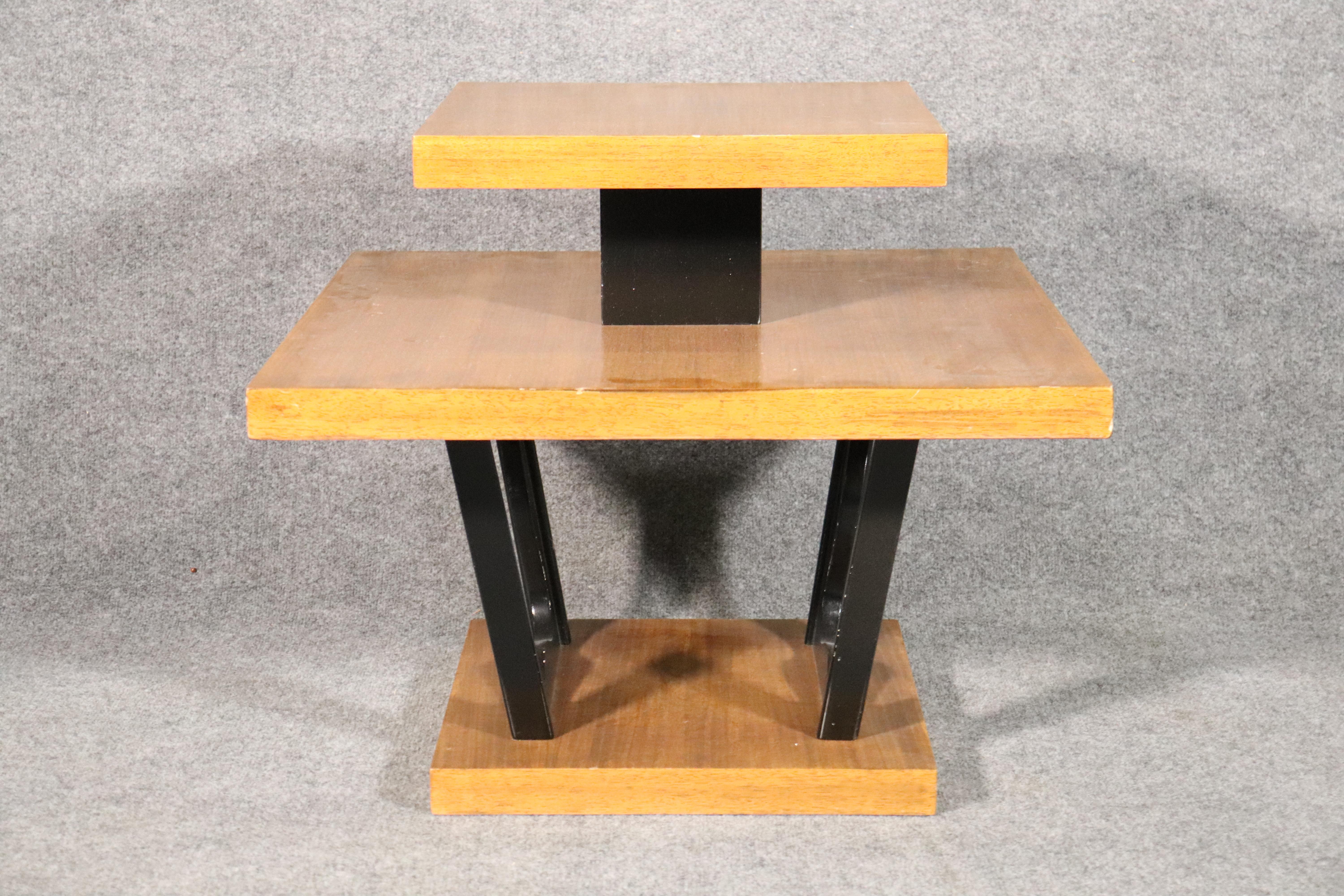 Unique two tone table with blonde mahogany grain and black accenting supports. 
Please confirm location