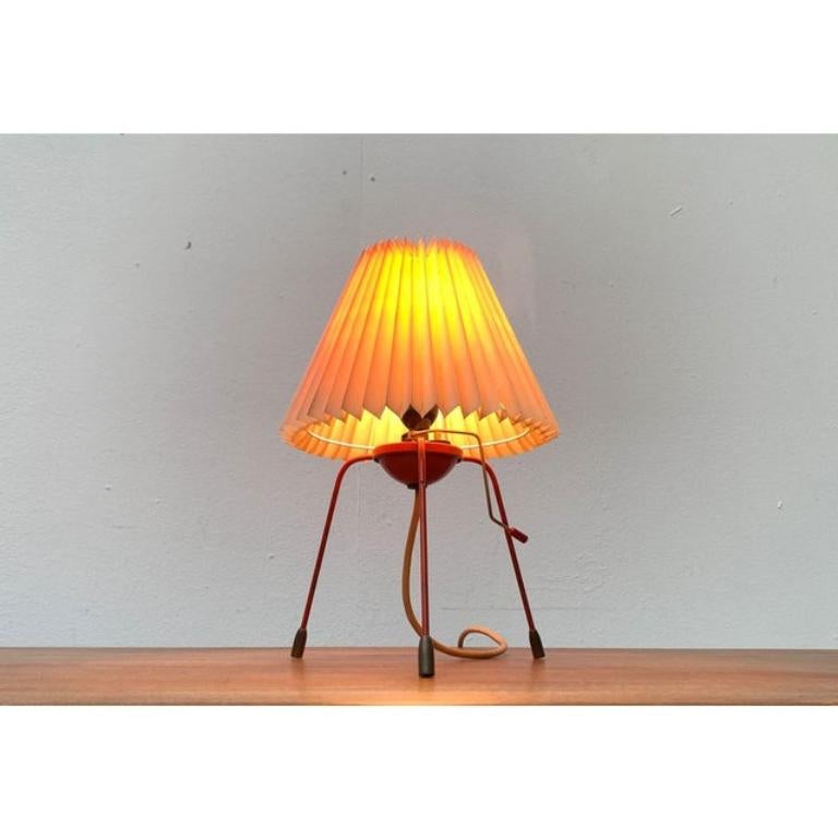 Very rare Tripod table lamp by Napako based on a design by Josef Hurka.

This design lives from the contrast between the shade and the base. The frame with its technical design language is opposed by a decorative lampshade. The fine frame of the