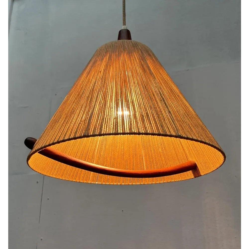 Mid Century train pendulum from Temde.

A draft of special materiality and complex execution. Object in the room and functional light source in one. The cone -shaped umbrella is covered with a thread made of Sisal. This natural diffuser material