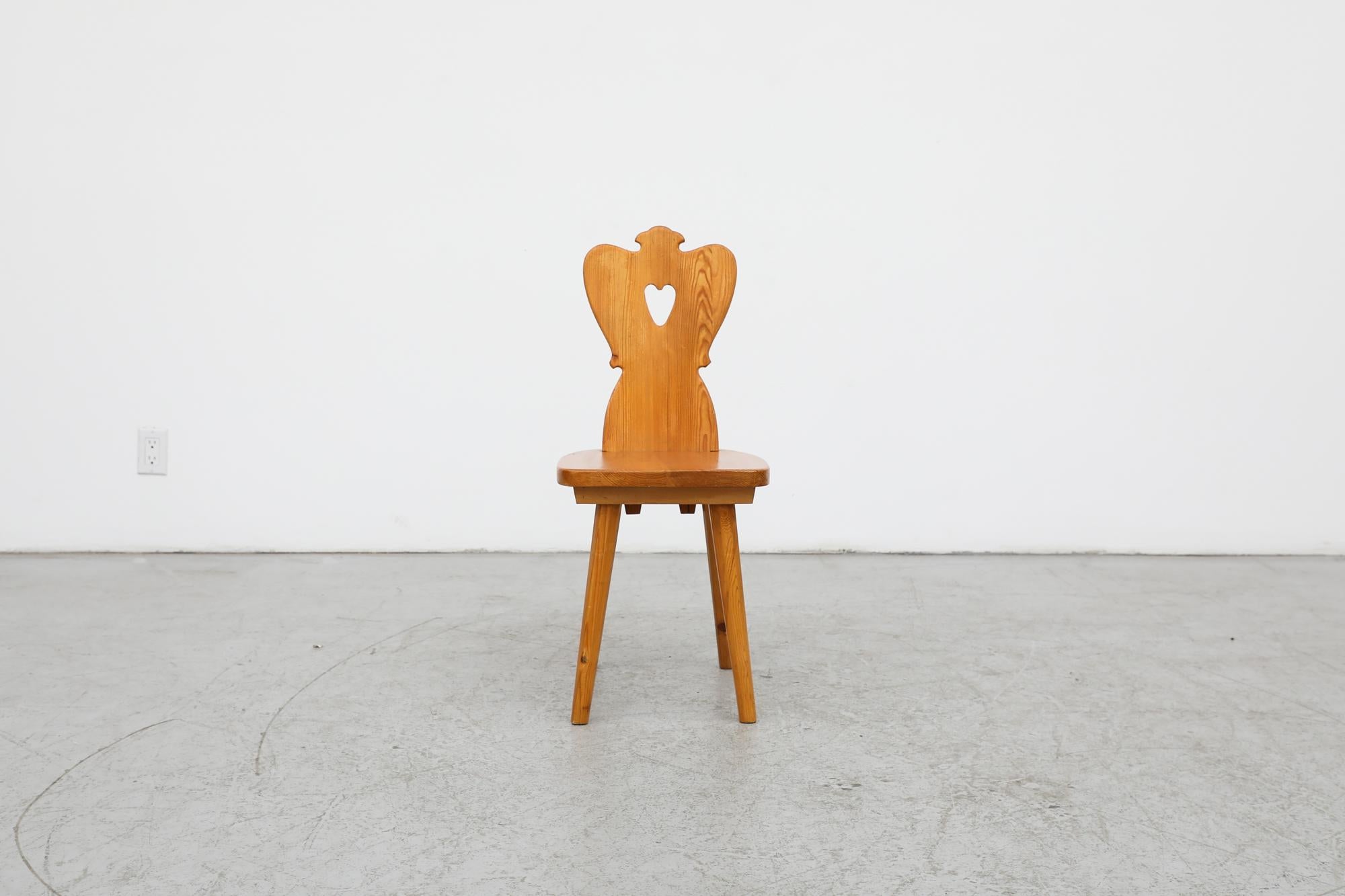 Beautiful little Tyrolean style side chair. This solid wood chair has tapered legs with a folk art heart shaped design carved into the backrest. In original condition with visible wear consistent with its age and use. A matching pair also available,