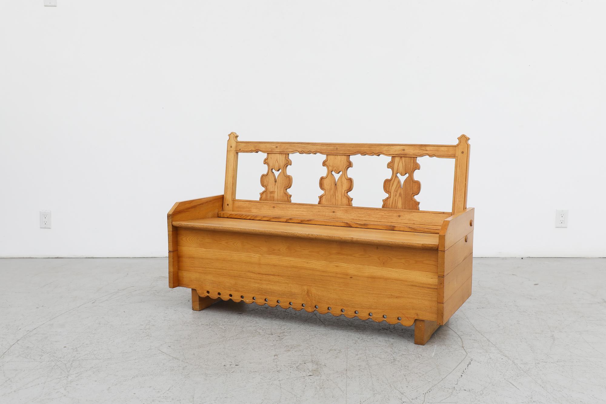 Mid-Century Tyrolean style ornate pine storage bench. This charming bench doubles as a blanket chest with beautiful ornate carvings throughout the piece. In original condition with visible wear consistent with its age and use.