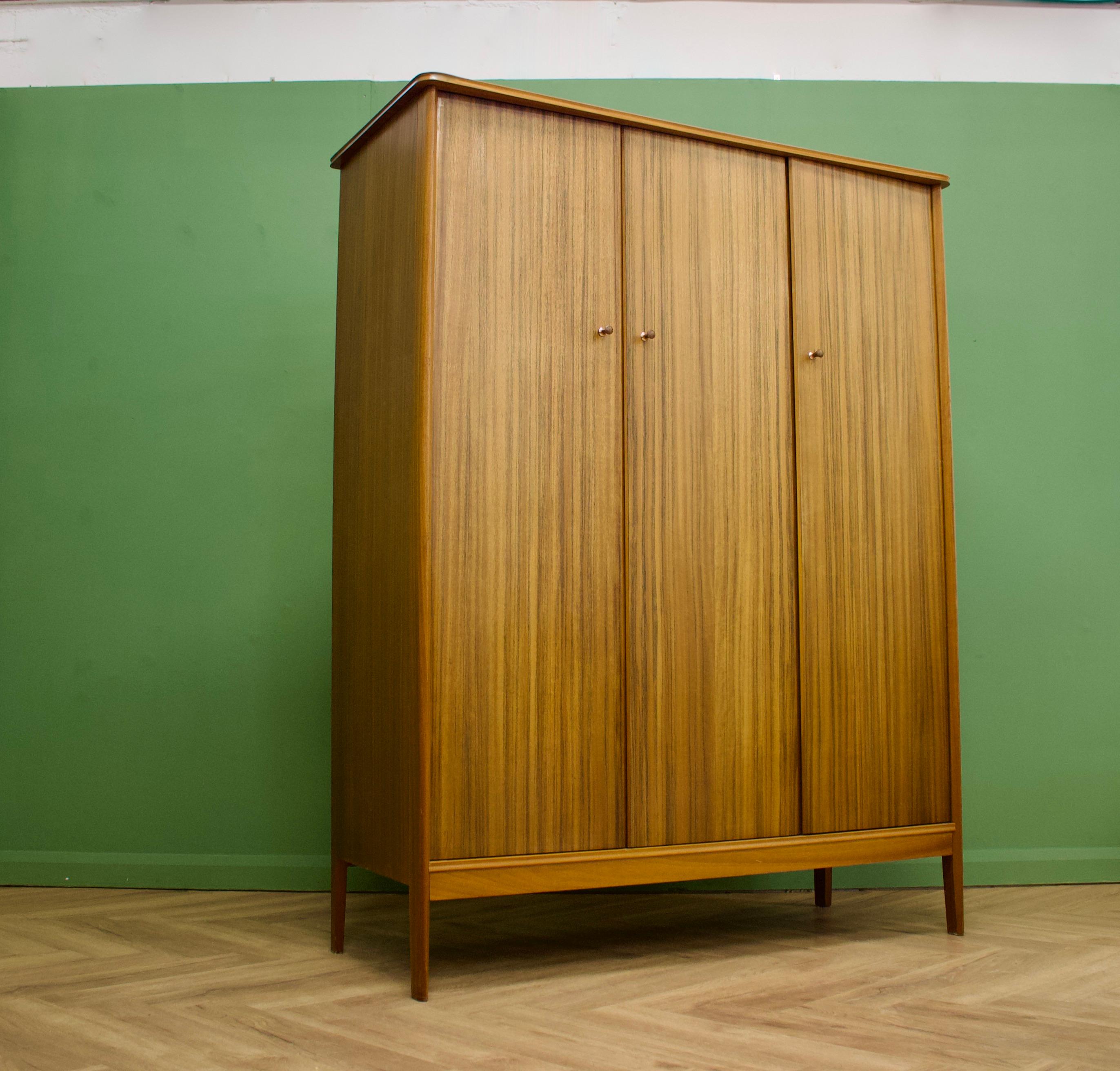Mid-Century Modern triple door wardrobe by Vanson 
Manufactured in the UK.
Made from solid teak and real teak veneers.
Featuring 2 rails, shoe rail and a shelf
This wardrobe dismantles.

