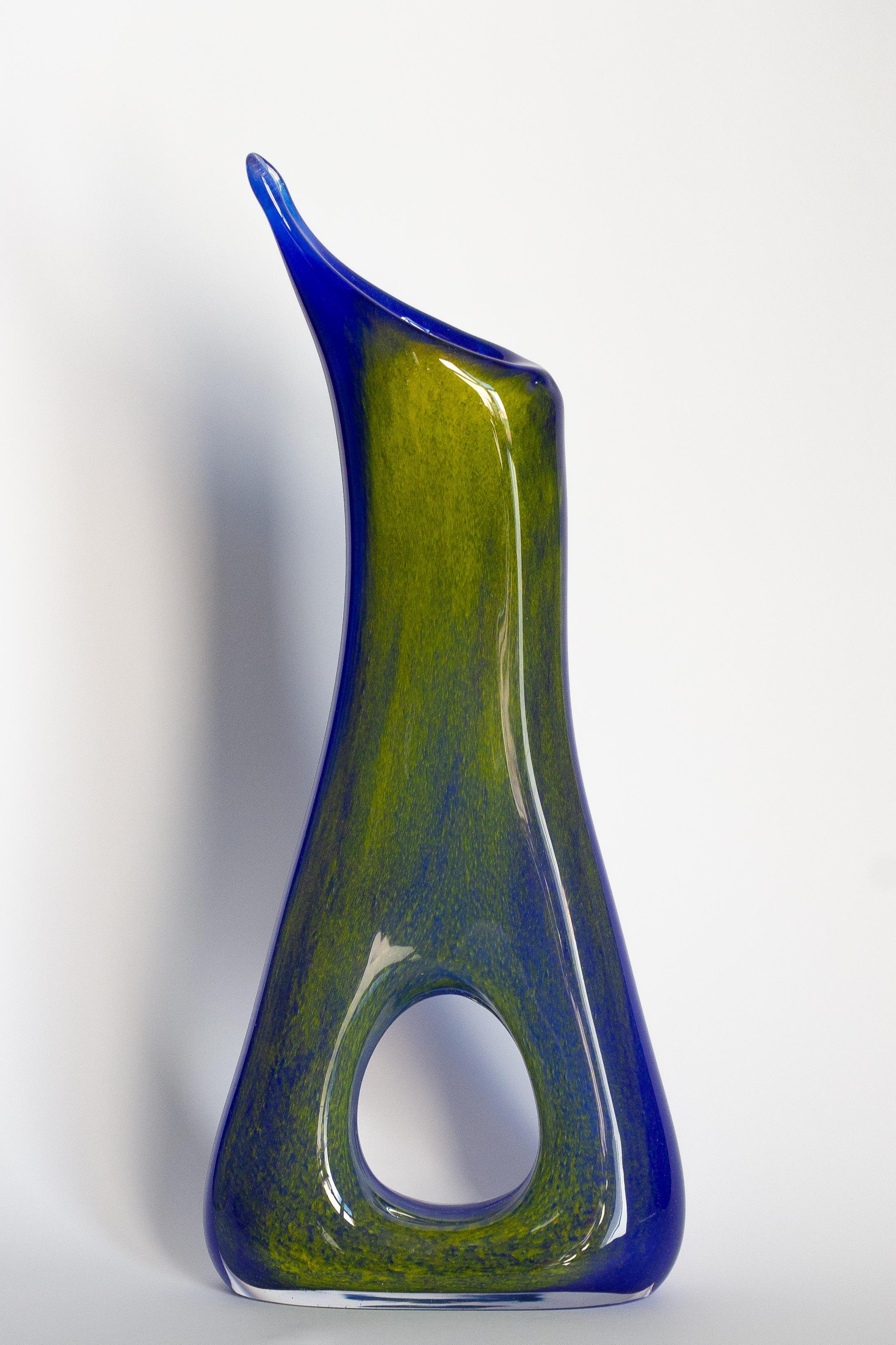 Vase bleu de forme organique étonnante. Produit dans les années 1960.
Verre en parfait état. Le vase semble avoir été sorti de sa boîte.

Pas d'accrocs, de défauts, etc. La surface extérieure en relief, l'intérieur lisse. Vase en verre épais,