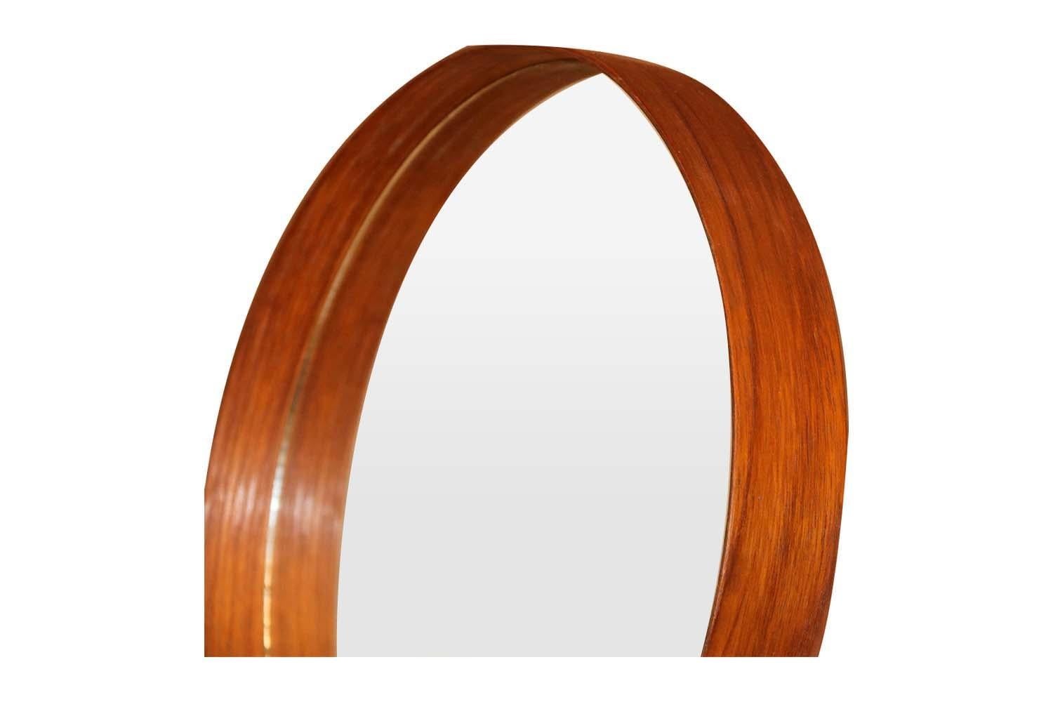 A fabulous table mirror designed by Uno and O¨sten Kristiansson for Luxus, Sweden, 1960. Remaining in gorgeous condition. Features a circular teak frame, in a striking teak finish, the mirror is supported on dovetail L-shaped angled legs exquisite