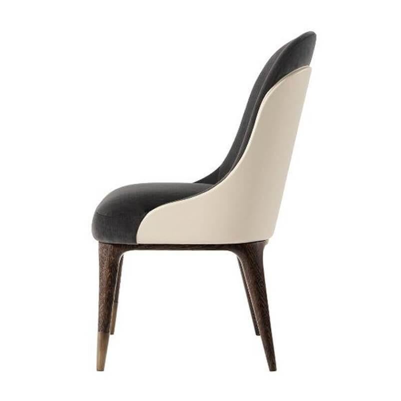 Elegant Mid-Century Modern style upholstered dining chair. With a leather wrapped tailored backrest, upholstered back and seat, oak legs and stainless steel antiqued bronze finish feet.

Dimensions: 21.25