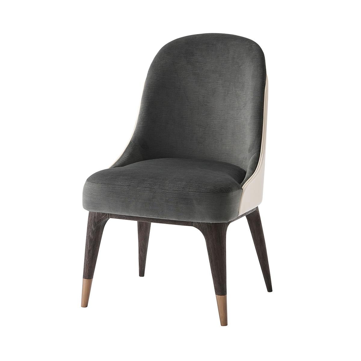 Elegante sedia da pranzo imbottita in stile Mid Century Modern. Con schienale su misura rivestito in pelle, schienale e seduta imbottiti, gambe in Oak e piedi in acciaio inossidabile con finitura bronzo anticato.

Dimensioni: 21,25