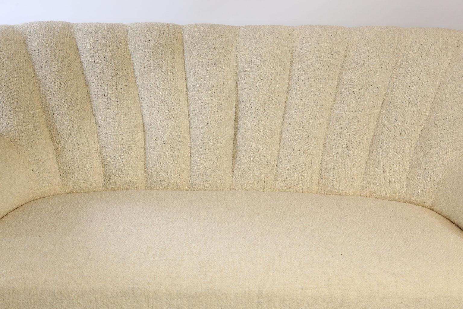 Found in Paris, this midcentury settee is presented in a beautiful cream upholstery. Designed with clean lines and a tufted back this settee will add a touch of modern to your home.
