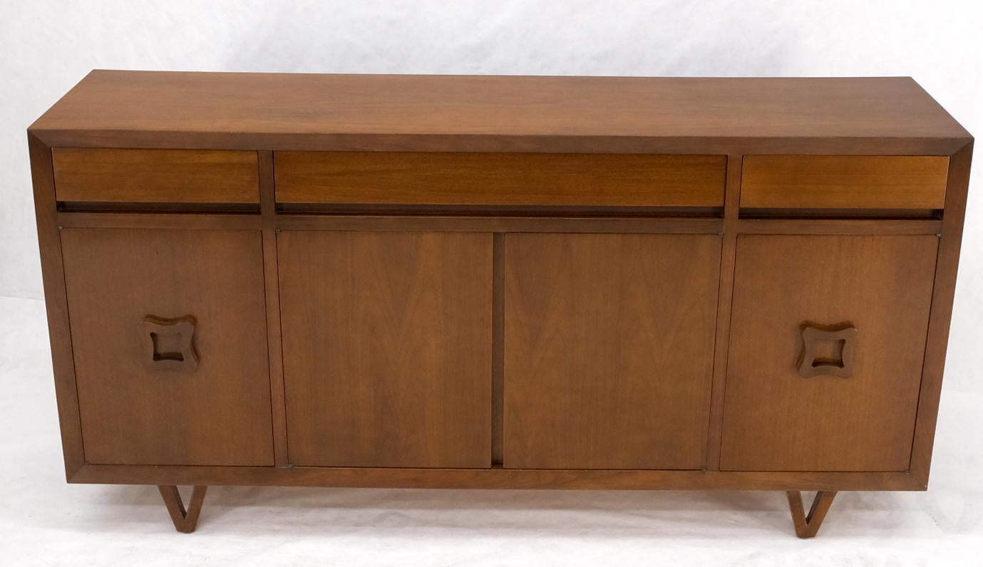 James Mont influence walnut Mid-Century Modern credenza cabinet sideboard with figural pulls V shape legs 4 doors compartment and three top drawers.