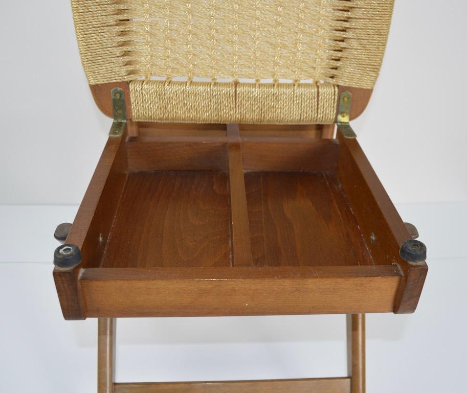 Stylish midcentury valet, probably American in the Italian style. The valet features a change tray, retractable hanging arms for ties, hats etc, hanger for your jacket or shirt, and a lift up seat with hidden storage. Measures: Seat H 17 inch. Nice,