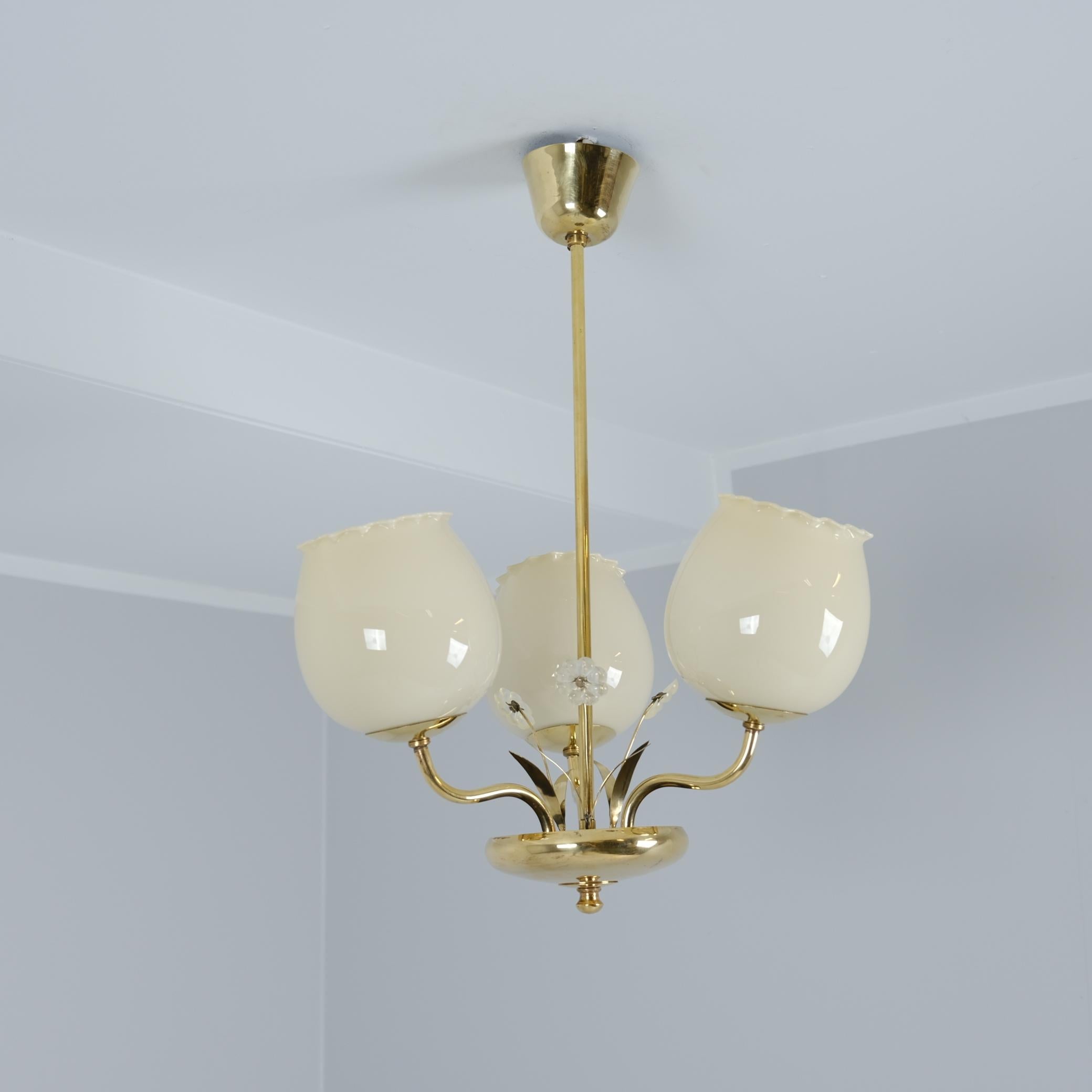 Eine schöne und filigrane finnische Deckenlampe Modell 2538/3 von Valinte um 1950, einem der führenden finnischen Beleuchtungshersteller, aus der Mitte des letzten Jahrhunderts. Die Leuchte hat drei Sockel mit Opalglasschirmen, die an Blütenknospen