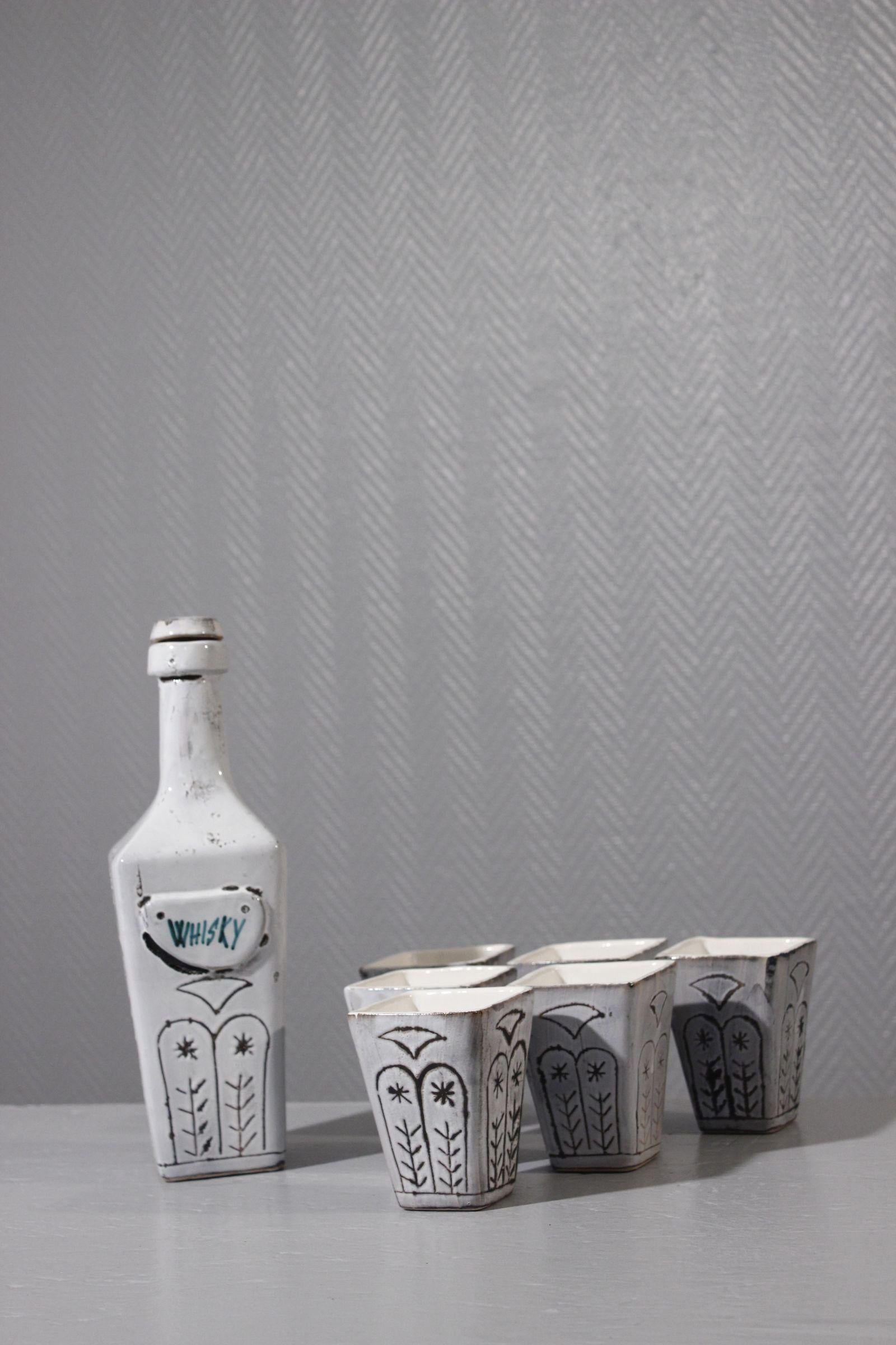 Service à whisky vers 1950 Faïence de Vallauris, décor incisé sur émail blanc

Complet avec 6 gobelets, en très bon état général. A noter de petits éclats sur le bord de deux gobelets, signature incisée de Vallauris sur le dessous. 

Dimensions de