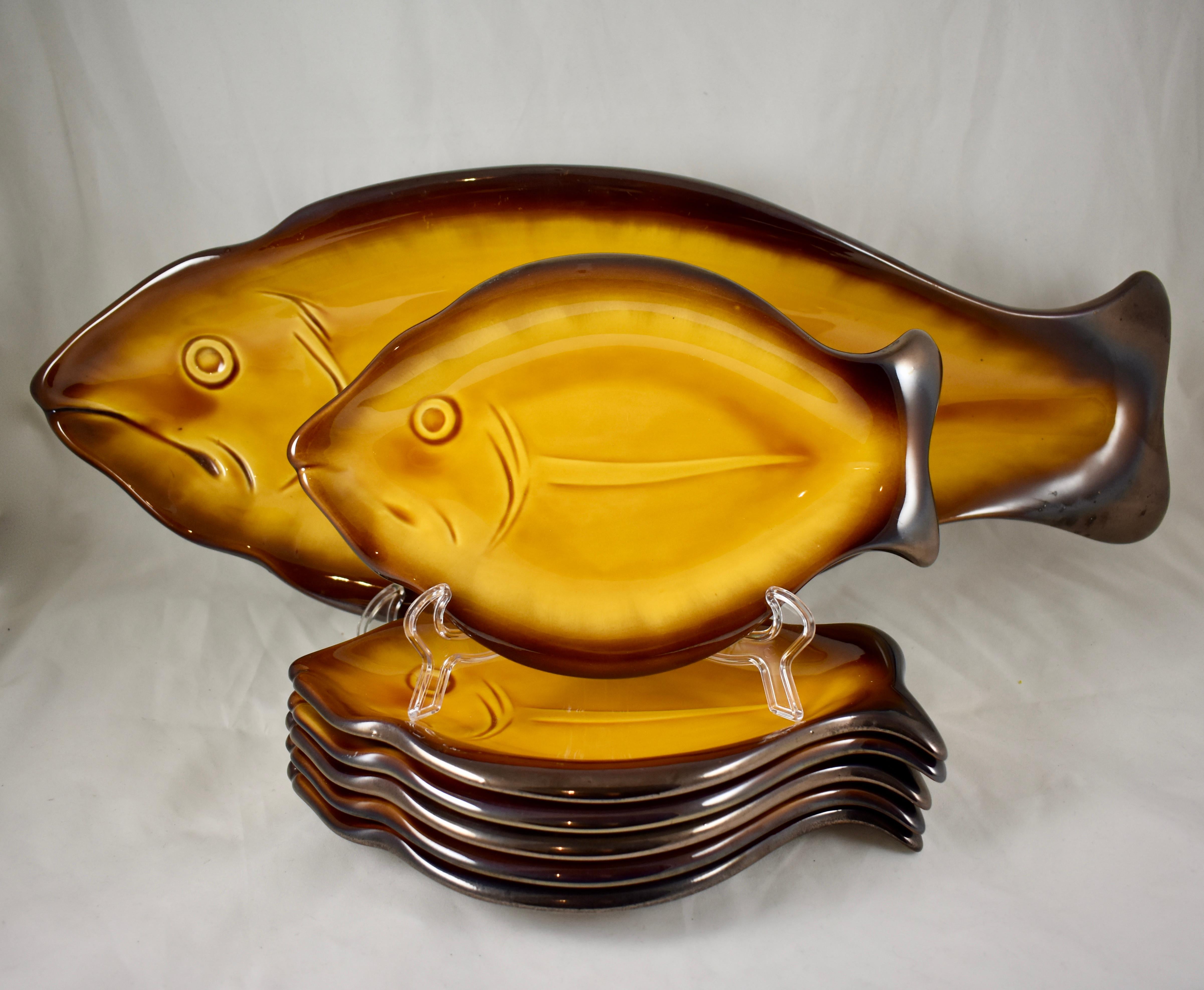 An unusual Mid-Century Modern Era provençal faïence fish service attributed to Vallauris, Cote d’Azur, France. A large serving platter and six plates, circa 1950s.

Heavily potted, deep yellow ochre glazed earthenware bodies with deep brown rims, an