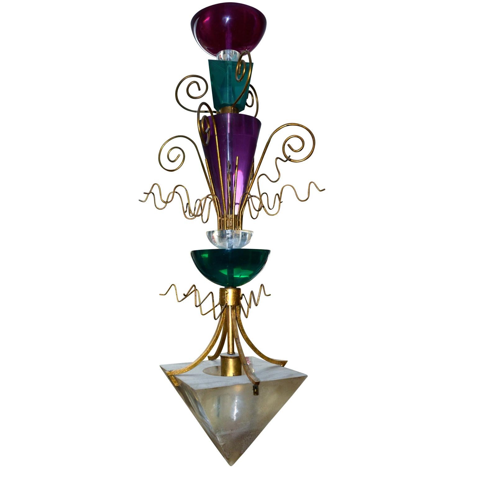 A Classic Van Teal 1960s chandelier having five large different colored and geometric shaped acrylic Lucite components stacked on top each other and terminating in a pyramid, each separated by a layer of twisted gilded metal decoration; the lowest