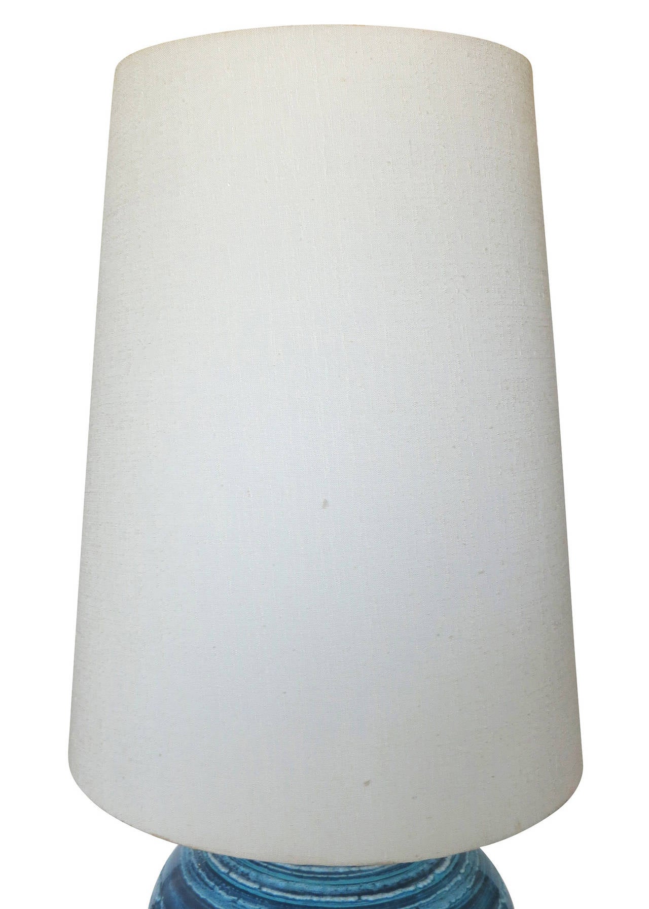 Une grande lampe en céramique émaillée à rayures bleues variées avec un abat-jour original transparent. Cette lampe est composée d'un pot en poterie bleu varié avec une base et un col en laiton plaqué bronze.

Lampe avec abat-jour 38,5